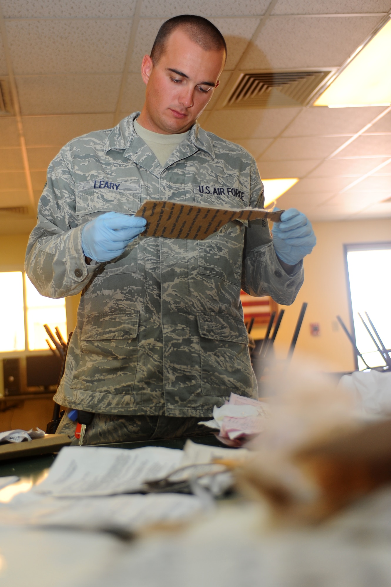 Staff Sgt. Shawn Leary, 379th Expeditionary Civil Engineer Squadron security escort, examines a piece of trash for operations security violations at a non-disclosed Southwest Asia location March 3, 2010. (U.S. Air Force photo by Senior Airman Kasey Zickmund)[RELEASED]
