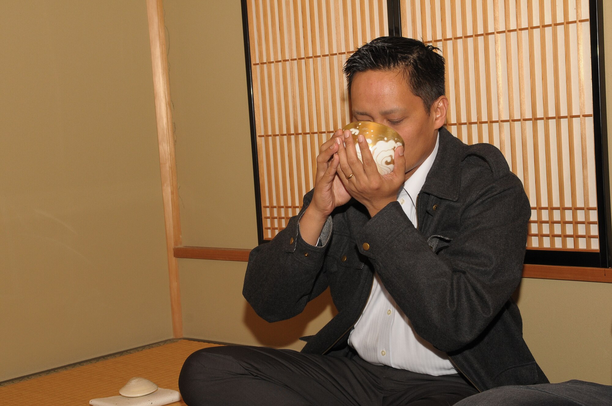 TACHIKAWA, Japan -- Capt Jerome Baquilar, 374th Civil Engineer Squadron, drinks traditional Japanese green tea Mar. 3 during a tour through the Japanese Garden at Showa Kinen Park. Park managers hosted the group of military and civilian residents of Yokota, to help them experience authentic Japanese culture. The Japanese government created Showa Park 1983 to commemorate the 50th anniversary of Emperor Showa's reign. (U.S. Air Force photo/Airman 1st Class Sean Martin)