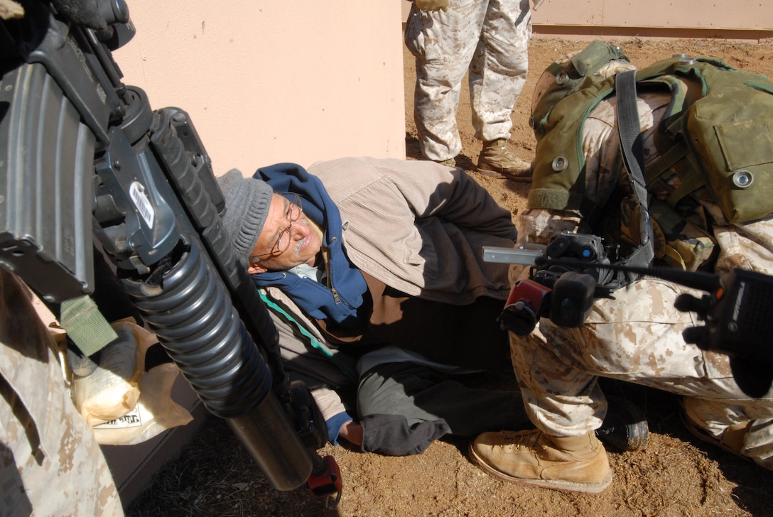 A U.S. Marine lieutenant wraps an Afghan-American actor's leg during a similated leg wound during a training exercise at the Military Operations in Urban Terrain Training Center, Camp Barrett, on Marine Corps Base Quantico, Va., March 4, 2010. 
