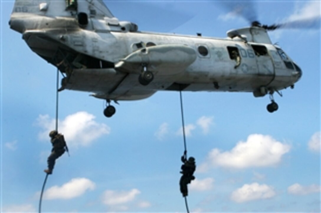 U.S. Marines fast-rope from a CH-46E Sea Knight helicopter onto