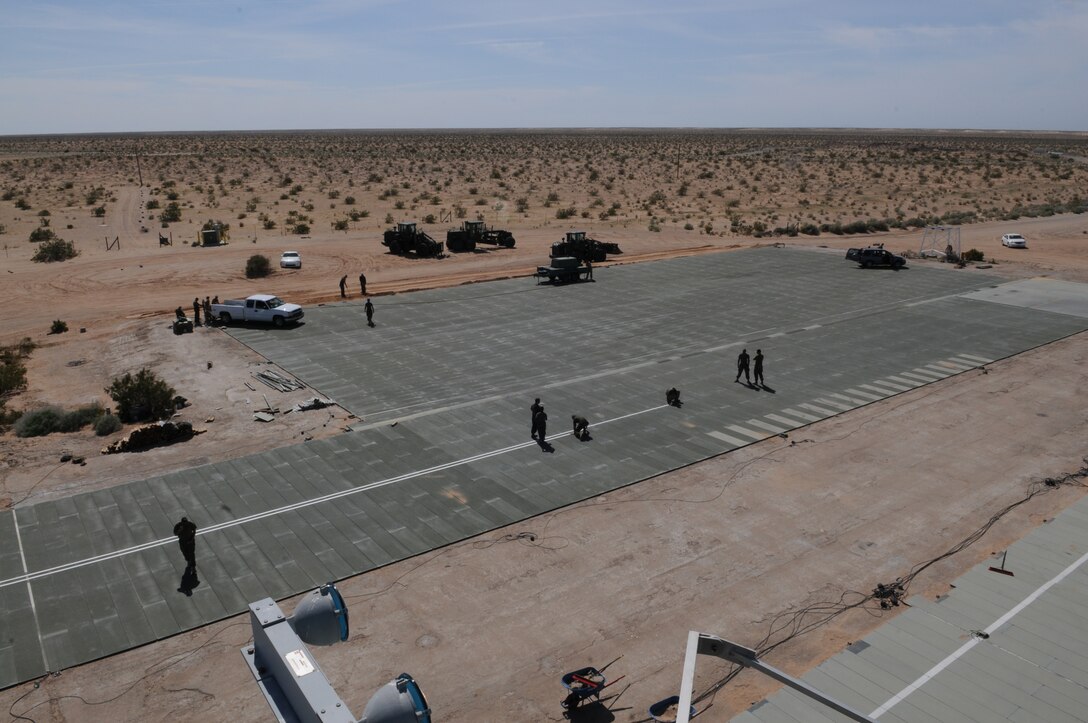 Marines and sailors from Marine Wing Support Squadron 371 work to replace the maintenance pad’s mats at Auxiliary Airfield 2 March 3, 2010. MWSS-371 replaced 40,060 square feet of matting which made up the taxiway and maintenance pad so Aux-2 could pass its annual recertification so squadrons can use it for another year of carrier landings training. MWSS-371 is based at the Marine Corps Air Station in Yuma, Ariz. The auxiliary airfield is located on the Barry M. Goldwater Range east of the station.
