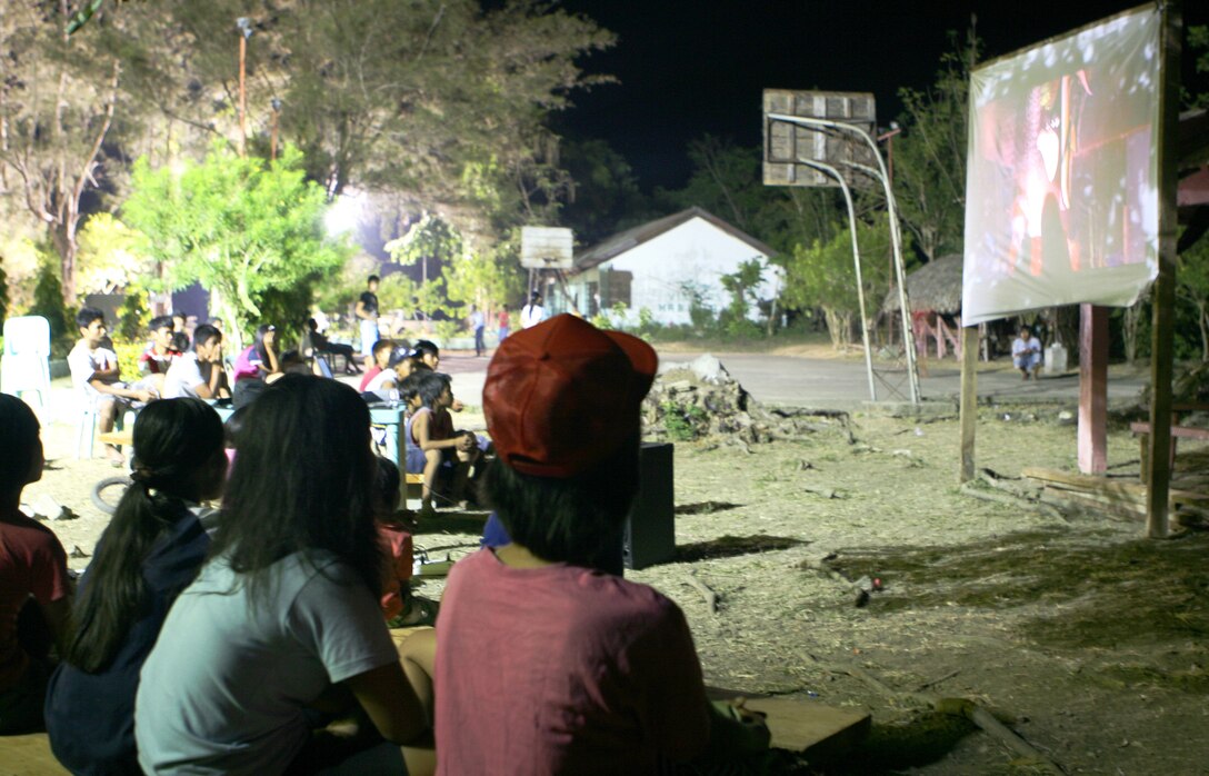 Local children and adults watch a movie on an improvised movie theater, March 6. Marines and sailors with CLB-31 are currently renovating Marnay Primary School in support of Balikatan 2010 (BK ’10). Servicemembers from the Armed Forces of the Philippines (AFP) and the 31st MEU are training together during BK ’10 to hone their civil-military interoperability skills to ensure more responsive, efficient and effective relief efforts.