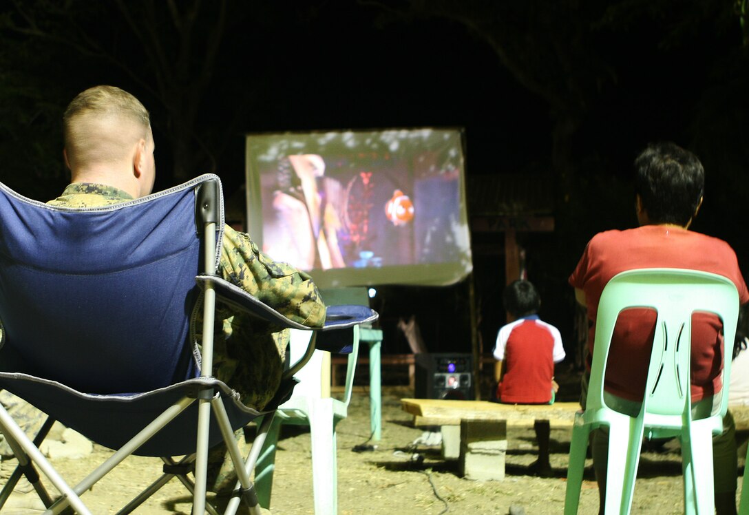 Marines and sailors with Combat Logistics Battalion 31 (CLB-31), 31st Marine Expeditionary Unit (MEU), sit among local children during a movie night, March 6. CLB-31 is currently renovating Marnay Primary School in support of Balikatan 2010 (BK ’10). Servicemembers from the Armed Forces of the Philippines (AFP) and the 31st MEU are training together during BK ’10 to hone their civil-military interoperability skills to ensure more responsive, efficient and effective relief efforts.