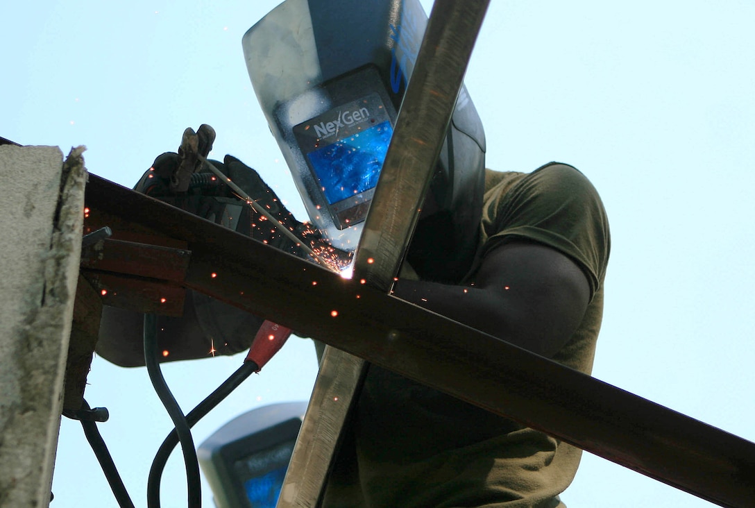 Lance Cpl. Lansana J. Kiazolu, a metal working specialist with Combat Logistics Battalion 31 (CLB-31), 31st Marine Expeditionary Unit (MEU), welds a truss to a support beam atop of a roof during a renovation of a two-room classroom in support of exercise Balikatan 2010 (BK ’10), March 7. Servicemembers from the Armed Forces of the Philippines (AFP) and the 31st MEU are training together during BK ’10 to hone their civil-military interoperability skills to ensure more responsive, efficient and effective relief efforts.
