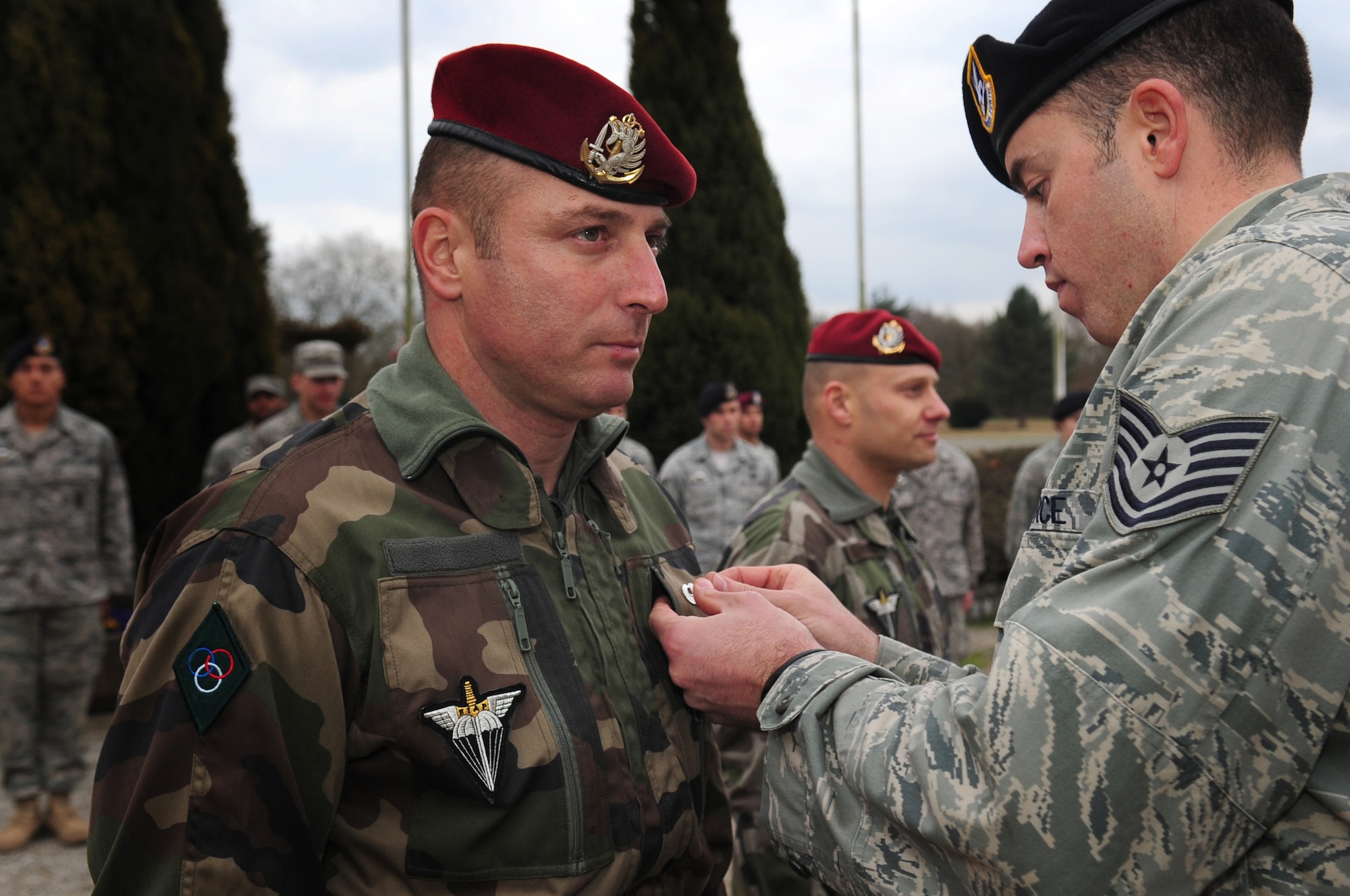 After a week of training and jumping together, U.S. Air Force Tech. Sgt. Jason Shaffer presents U.S. military jump wings to French Airborne Academy instructor Master Sgt. Stephane Paternotte during a formal ceremony concluding the week, March 4, 2010.  Members of the 435th Contingency Response Group and the 5th Quartermaster Company joined with their French military counterparts for a week of training at the École des troupes aéroportées (ETAP), or School of Airborne Troops, a military school dedicated to training the military paratroopers   of the French army, located in the town of Pau, in the département  of Pyrénées-Atlantiques , France.  The ETAP is responsible for training paratroopers, and for international cooperation and promotion of paratroop culture. (U.S. Air Force Photo by Staff Sgt. Jocelyn Rich)