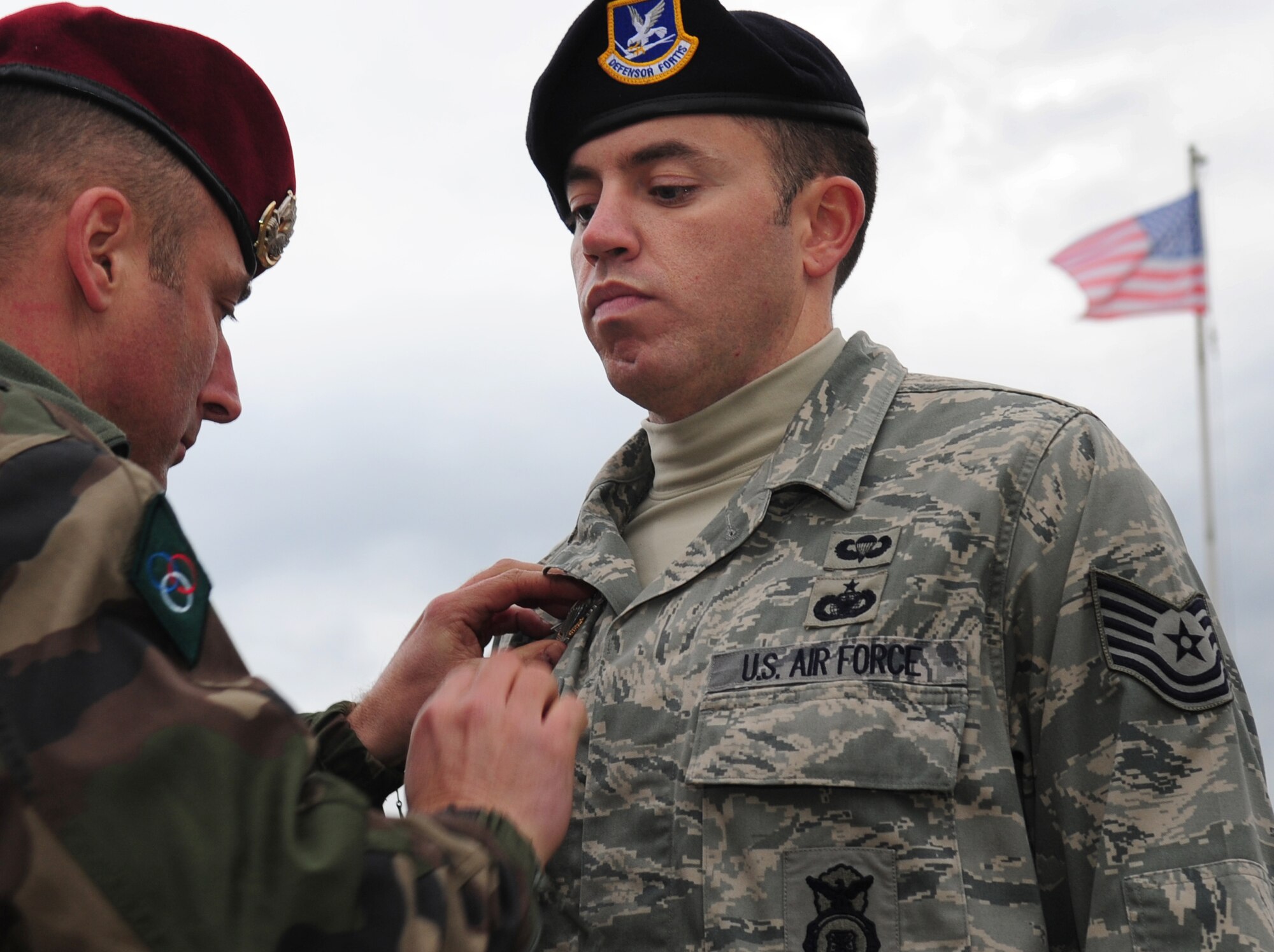 After a week of training and jumping together, Academy instructor Master Sgt. Stephane Paternotte presents U.S. Air Force Tech. Sgt. Jason Shaffer French jump wings during a formal ceremony concluding the week, March 4, 2010.  Members of the 435th Contingency Response Group and the 5th Quartermaster Company joined with their French military counterparts for a week of training at the École des troupes aéroportées (ETAP), or School of Airborne Troops, a military school dedicated to training the military paratroopers   of the French army, located in the town of Pau, in the département  of Pyrénées-Atlantiques , France.  The ETAP is responsible for training paratroopers, and for international cooperation and promotion of paratroop culture. (U.S. Air Force Photo by Staff Sgt. Jocelyn Rich)