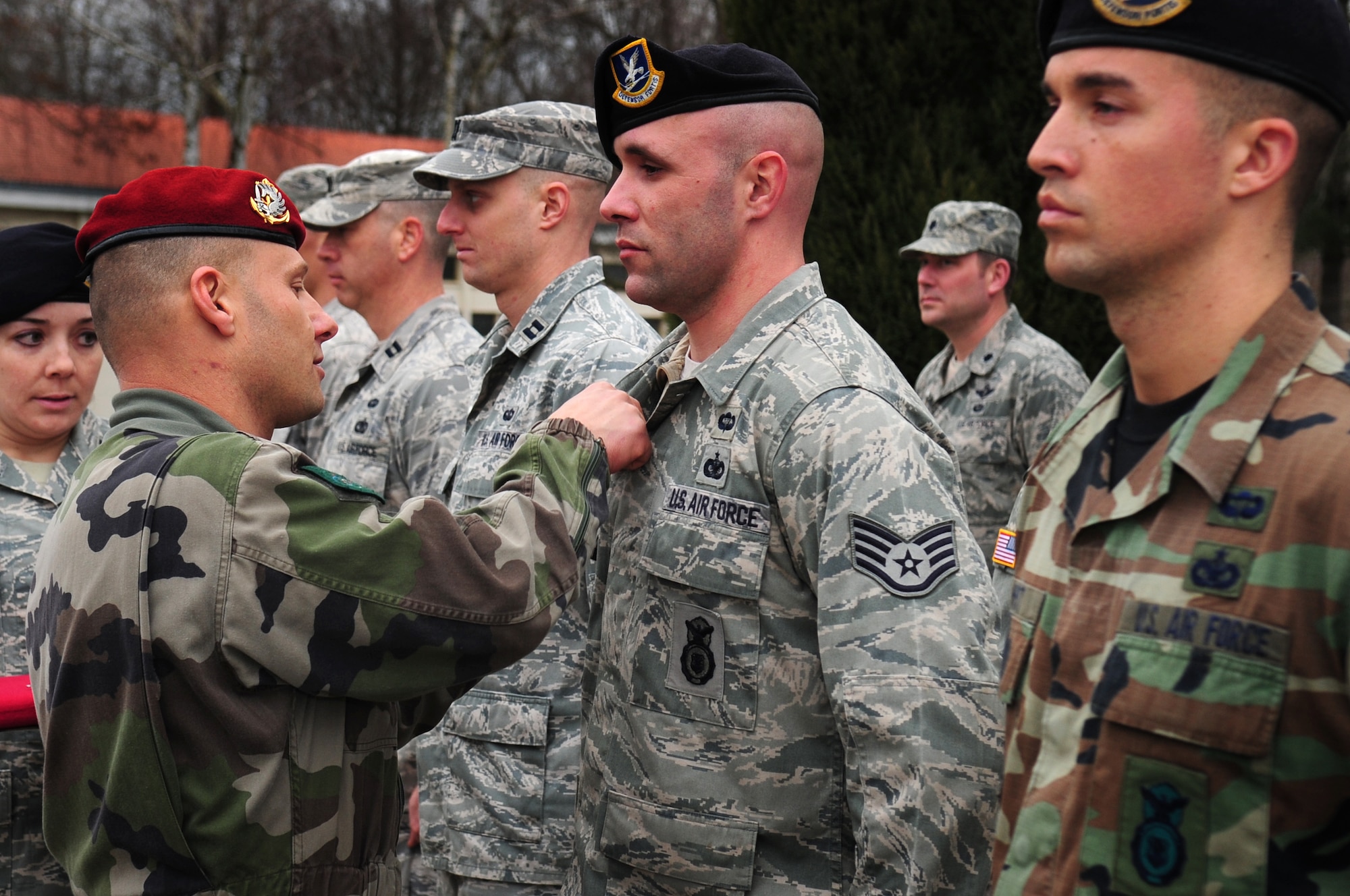 After a week of training and jumping together, Academy instructor Master Sgt. Stephane Paternotte presents U.S. military members with French jump wings during a formal ceremony concluding the week, March 4, 2010.  Members of the 435th Contingency Response Group and the 5th Quartermaster Company joined with their French military counterparts for a week of training at the École des troupes aéroportées (ETAP), or School of Airborne Troops, a military school dedicated to training the military paratroopers   of the French army, located in the town of Pau, in the département  of Pyrénées-Atlantiques , France.  The ETAP is responsible for training paratroopers, and for international cooperation and promotion of paratroop culture. (U.S. Air Force Photo by Staff Sgt. Jocelyn Rich)