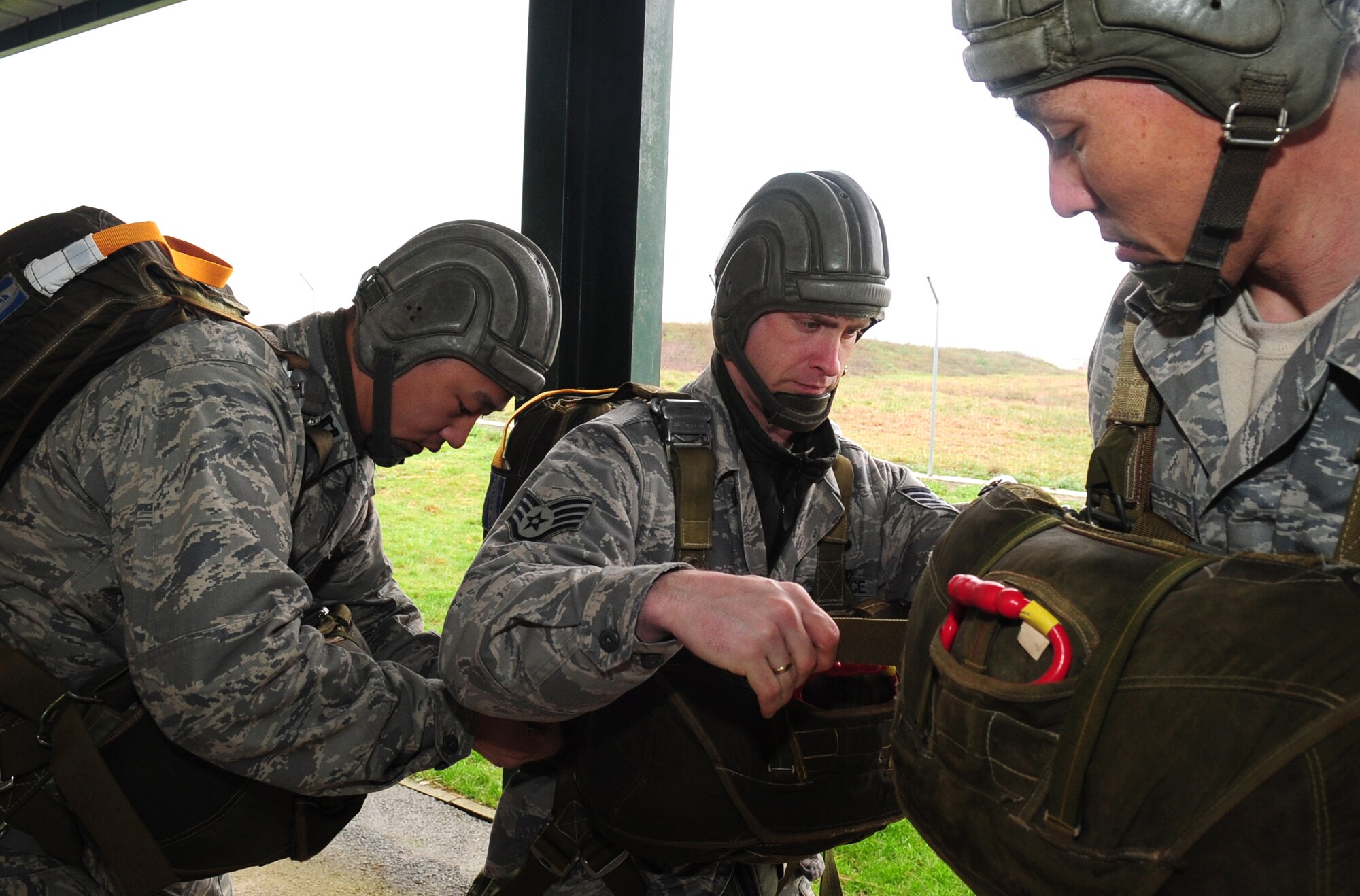 U.S. Air Force Captain Walter Gray, Staff Sgt. Ronald Booth, and Tech. Sgt. Randal Komaki, check  on each other?s  equipment while donning French parachutes before a multinational jump with French paratroopers , March 4, 2010.  Members of the 435th Contingency Response Group and the 5th Quartermaster Company joined with their French military counterparts for a week of training at the École des troupes aéroportées (ETAP), or School of Airborne Troops, a military school dedicated to training the military paratroopers   of the French army, located in the town of Pau, in the département  of Pyrénées-Atlantiques , France.  The ETAP is responsible for training paratroopers, and for international cooperation and promotion of paratroop culture. (U.S. Air Force Photo by Staff Sgt. Jocelyn Rich)