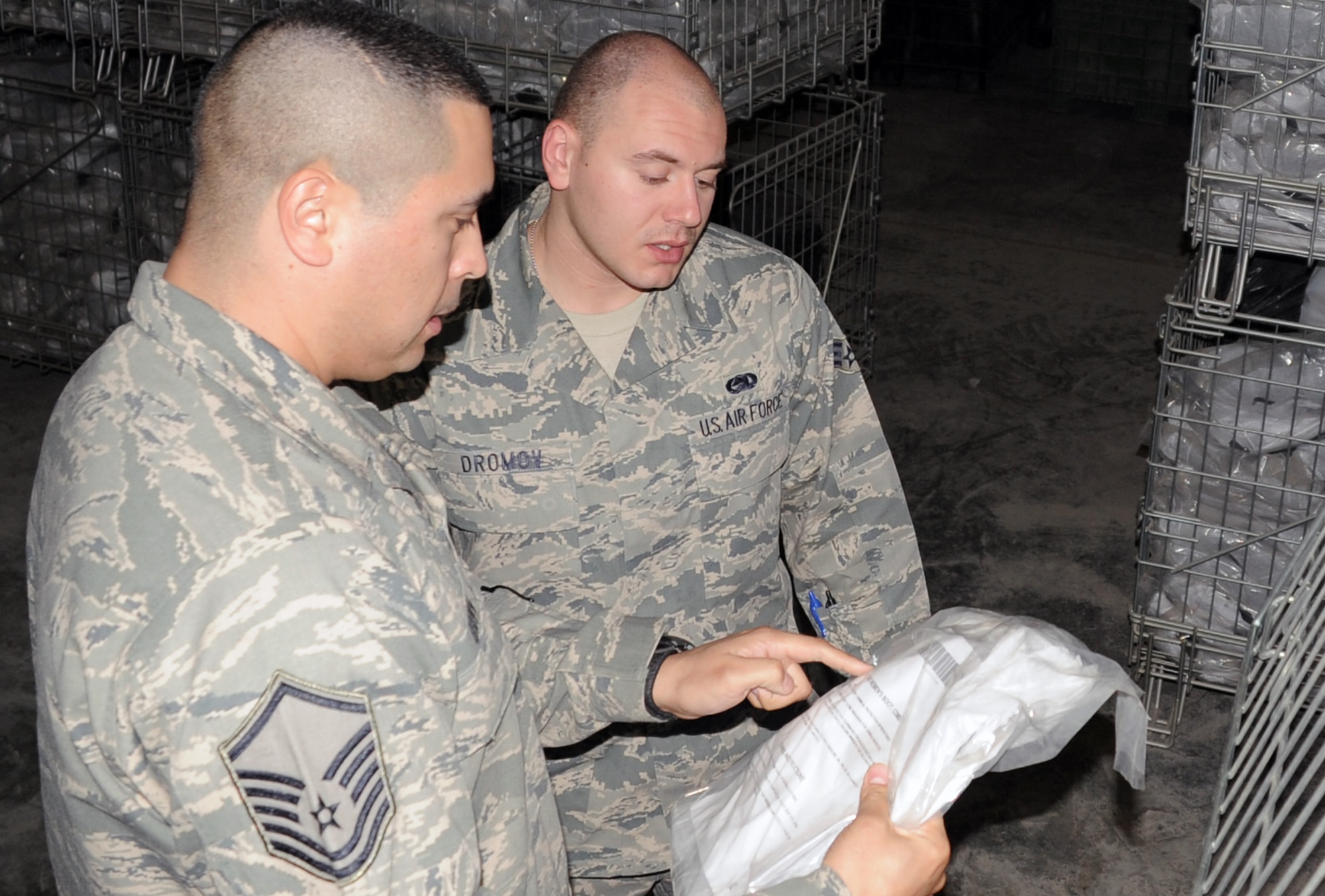Master Sgt. Alex Brown checks over inventory numbers with Senior Airman Alex Dromov in the supply warehouse for the 380th Expeditionary Logistics Readiness Squadron at a non-disclosed base in Southwest Asia on March 6, 2010. Both work in the ?Desert Depot,? otherwise known as the base supply store and both are material management Airman deployed with the 380th ELRS. (U.S. Air Force Photo/Master Sgt. Scott T. Sturkol)
