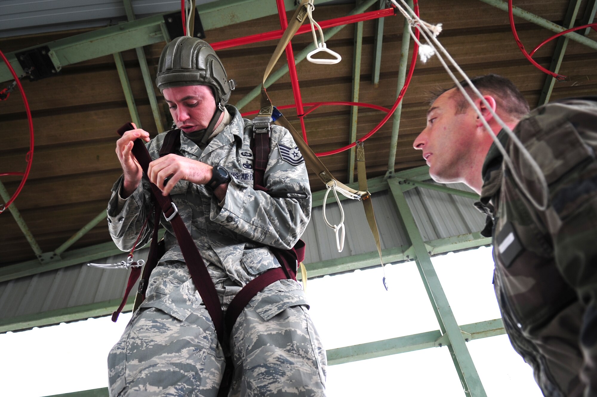 French Airborne Academy instructor Master Sgt. Stephane Paternotte, instructs U.S. Air Force Tech. Sgt. Jason Shaffer on proper body position while using a French parachute, durring training before a combined nation jump, March 3, 2010. Members of the 435th Contingency Response Group and the 5th Quartermaster Company joined with their French military counterparts for a week of training at the École des troupes aéroportées (ETAP), or School of Airborne Troops, a military school dedicated to training the military paratroopers   of the French army, located in the town of Pau, in the département of Pyrénées-Atlantiques, France.  The ETAP is responsible for training paratroopers, and for international cooperation and promotion of paratroop culture. (U.S. Air Force Photo by Staff Sgt. Jocelyn Rich)