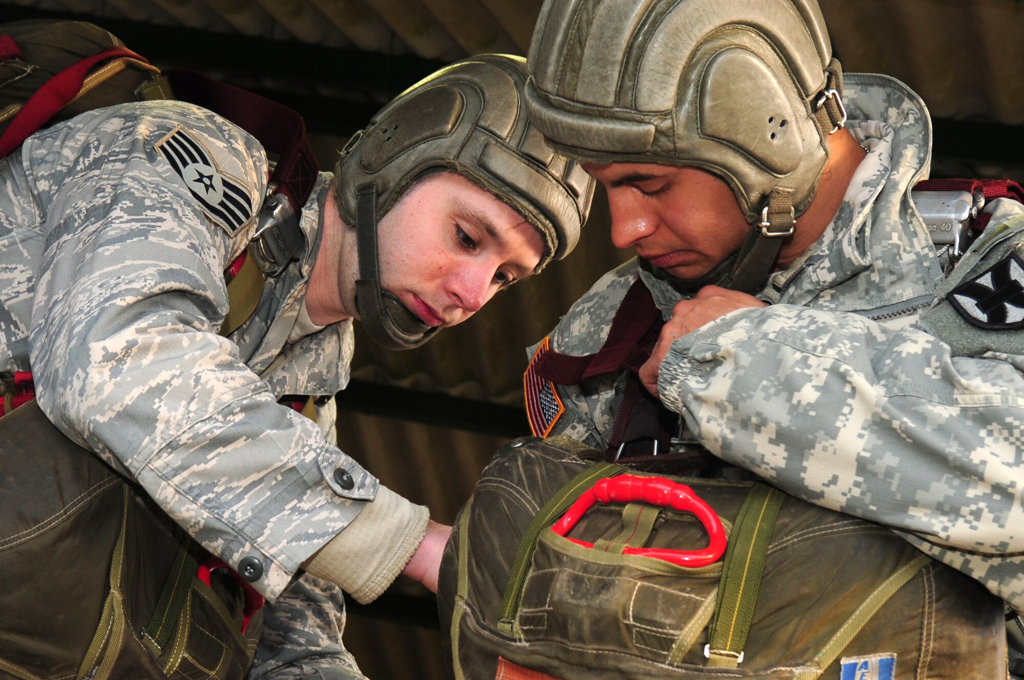 U.S. Air Force Staff Sgt. Derrick Drennan assists U.S. Army Specialist Eric Meneses in proper ware of the French parachute during training before a combined nation jump, March 3, 2010.   Members of the 435th Contingency Response Group and the 5th Quartermaster Company joined with their French military counterparts for a week of training at the École des troupes aéroportées (ETAP), or School of Airborne Troops, a military school dedicated to training the military paratroopers   of the French army, located in the town of Pau, in the département of Pyrénées-Atlantiques, France.  The ETAP is responsible for training paratroopers, and for international cooperation and promotion of paratroop culture. (U.S. Air Force Photo by Staff Sgt. Jocelyn Rich) 