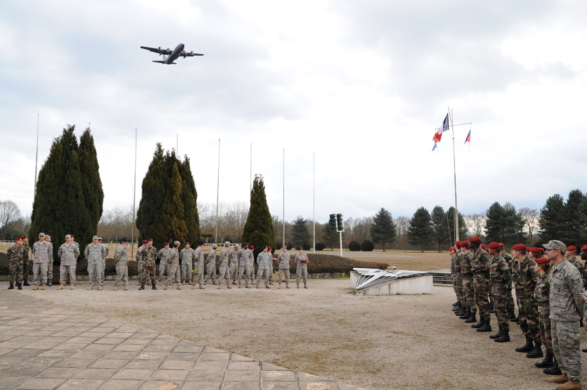 A C-130 flies over the airborne wings ceremony prior to them receiving their wings at École des troupes aéroportées (ETAP) Pau, France, March 4, 2010. Members of the 435th Contingency Response Group and the 5th Quartermaster Company joined with their French military counterparts for a week of training at the École des troupes aéroportées (ETAP), or School of Airborne Troops, a military school dedicated to training the military paratroopers  the French army, located in the town of Pau, in the département of Pyrénées-Atlantiques, France.  The ETAP is responsible for training paratroopers, and for international cooperation and promotion of paratroop culture. (U.S. Air Force photo by Airman 1st Class Caleb Pierce)