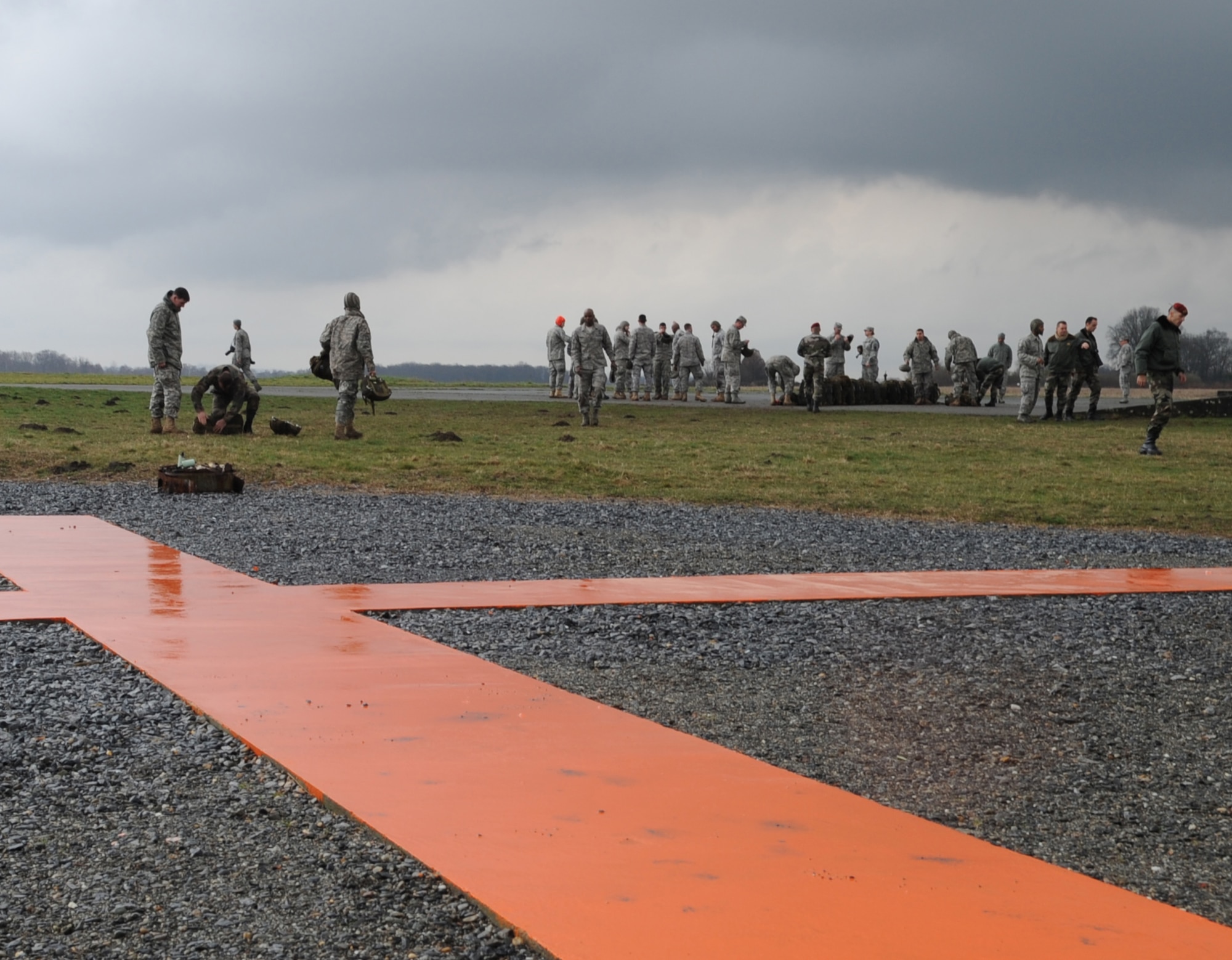 Airborne members meet on the drop zone after a static jump at École des troupes aéroportées (ETAP) Pau, France, March 4, 2010. Members of the 435th Contingency Response Group and the 5th Quartermaster Company joined with their French military counterparts for a week of training at the École des troupes aéroportées (ETAP), or School of Airborne Troops, a military school dedicated to training the military paratroopers  the French army, located in the town of Pau, in the département of Pyrénées-Atlantiques, France.  The ETAP is responsible for training paratroopers, and for international cooperation and promotion of paratroop culture. (U.S. Air Force photo by Airman 1st Class Caleb Pierce)