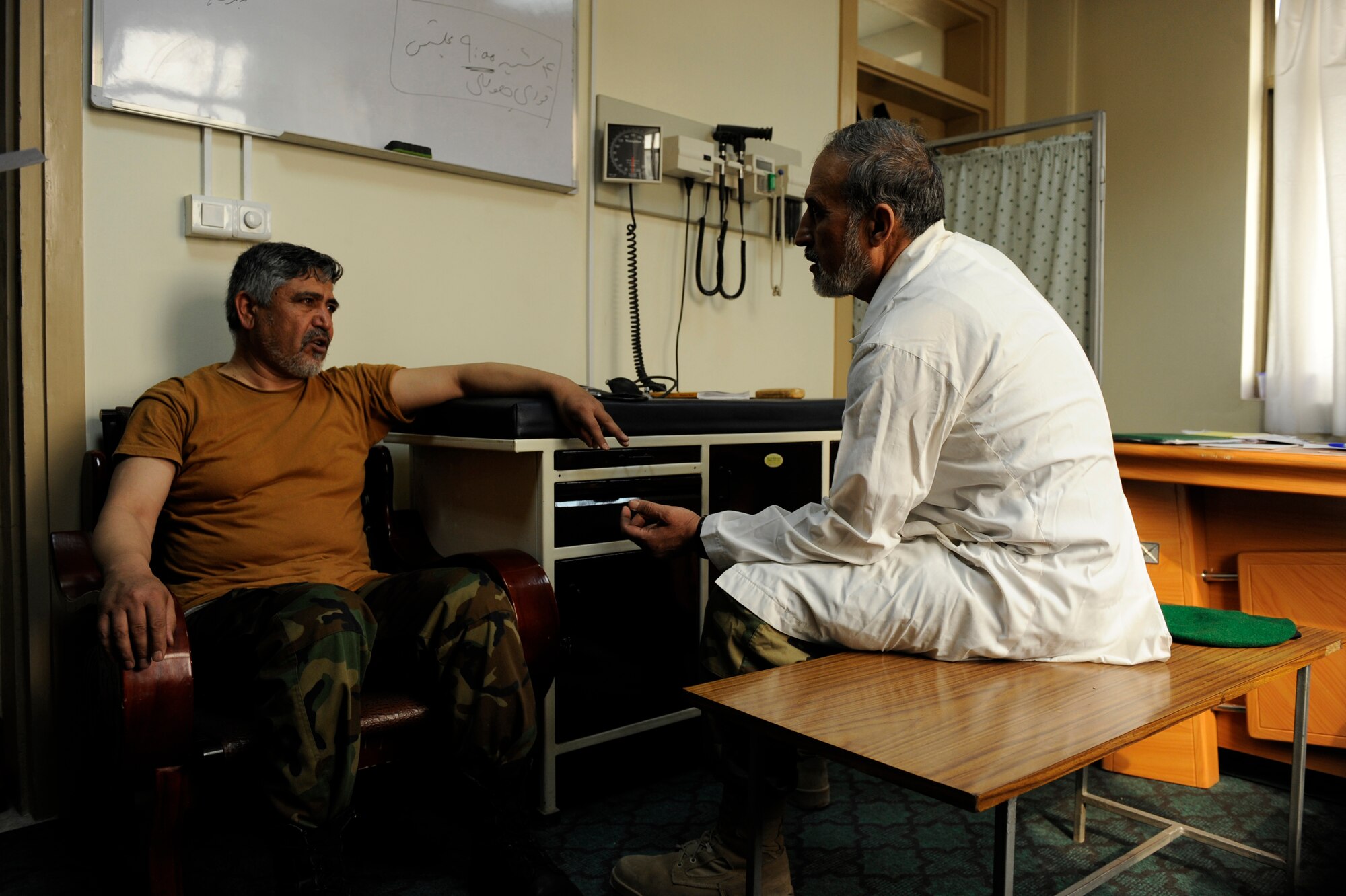 Afghan National Army Air Corps Col. Toryalay Sh-quraishee, Command Air Corps Medical Service Clinic commander and flight surgeon, speaks with an Afghan soldier during an appointment Feb. 23, 2010, at Kabul International Airport, Afghanistan. ?From my point of view, being able to treat our Afghan aircrews and pilots will save lives,? Colonel Sh-quraishee said. ?We can know if a pilot has high blood pressure, had alcohol or lack of sleep. Knowing this will ensure that we always have the right people flying missions.?  (U.S. Air Force photo/Staff Sgt. Manuel J. Martinez/released)
