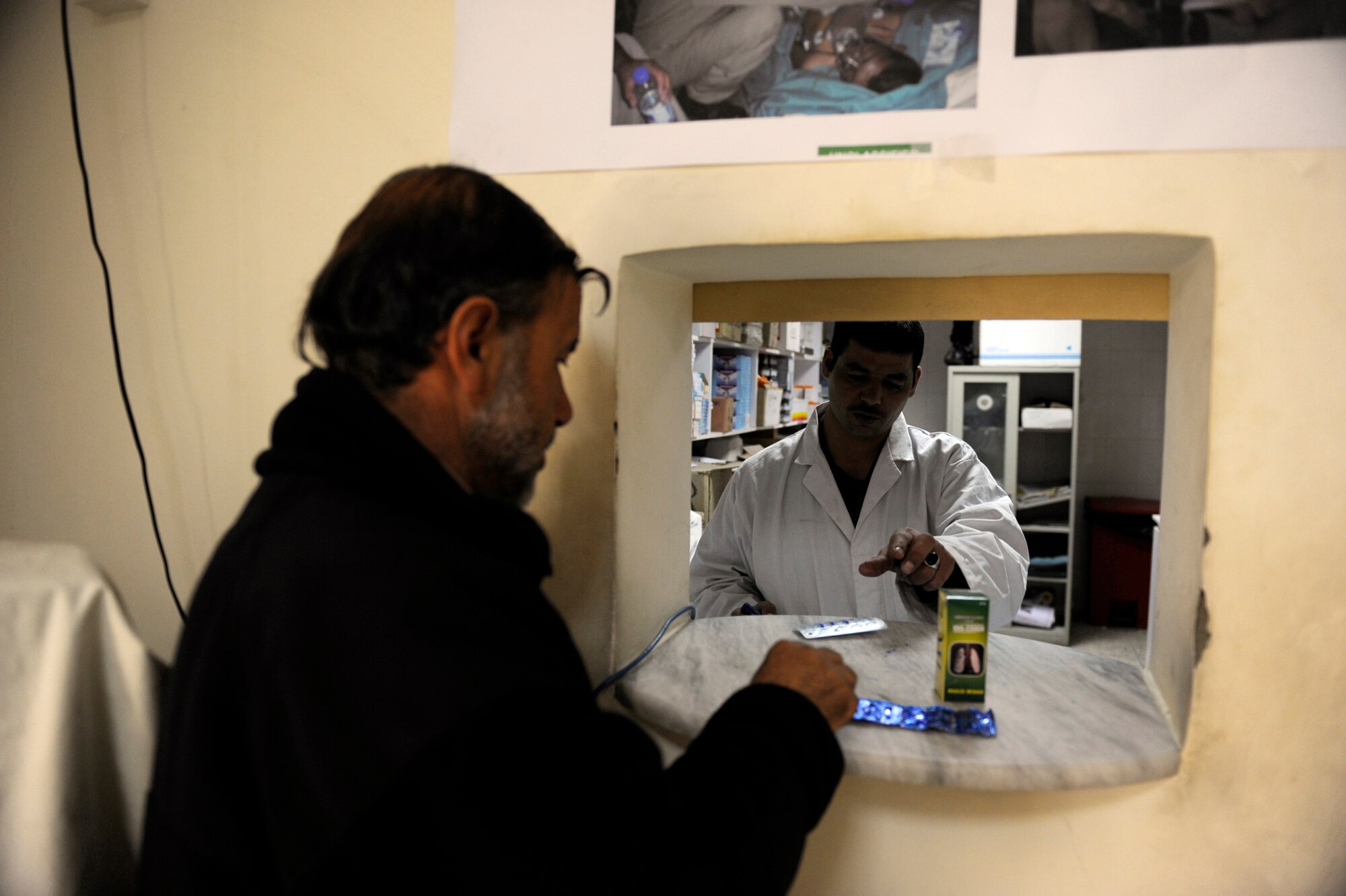Afghan National Army Air Corps Sgt. Asadullah Fageeri, Command Air Corps Medical Service Clinic pharmacy technician, hands an Afghan soldier his prescribed medication Feb. 23, 2010, in the clinic at Kabul International Airport, Afghanistan. (U.S. Air Force photo/Staff Sgt. Manuel J. Martinez/released)
