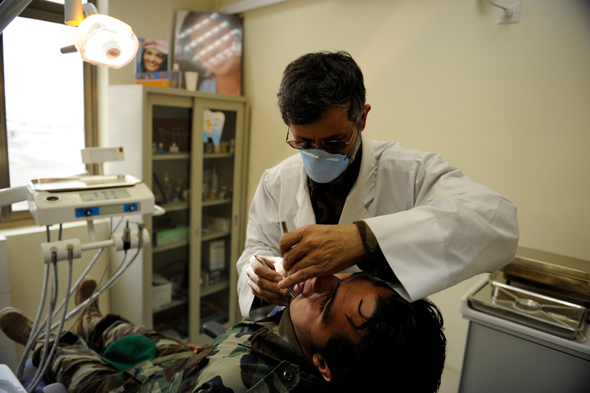 Afghan National Army Air Corps Major Azim Kazimy, Command Air Corps medical Service Clinic dentist, examines an Afghan soldier's teeth Feb. 23, 2010, at Kabul International Airport, Afghanistan. (U.S. Air Force photo/Staff Sgt. Manuel J. Martinez/released)