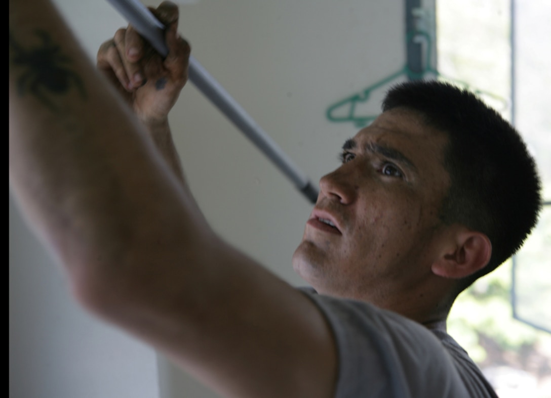 Lance Cpl. Robert H. Todacheene, a 25-year-old mortarman from Farmington, N.M., dusts a ceiling while volunteering at Sarakul Stadium here March 6. Service members aboard USS Rushmore cleaned and painted for the Phuket Athletic Club. The volunteers – service members with the 11th Marine Expeditionary Unit and Bonhomme Richard Amphibious Ready Group – spent the day fixing bent bed frames, cleaning rooms and painting beds and lockers. The stadium offers boys an alternative to growing up in Phuket neighborhoods where drugs and crime affect many young people.