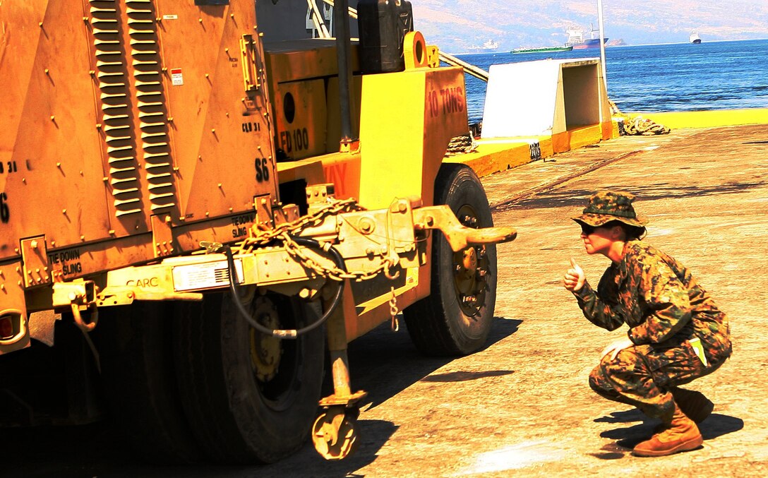 Cpl. Melissa Panzardi, a landing support specialist with Combat Logistics Battalion 31 (CLB-31), 31st Marine Expeditionary Unit (MEU), monitors the lifting of  a shipping container during the MEU’s offload phase in support of Balikatan 2010 (BK ’10), Mar. 6 - 7. Armed Forces of the Philippines (AFP) and the U.S. are working together during BK ’10 to hone their civil-military interoperability skills to ensure more responsive, efficient and effective relief efforts. (Official Marine Corps photo by Cpl. Michael A. Bianco)