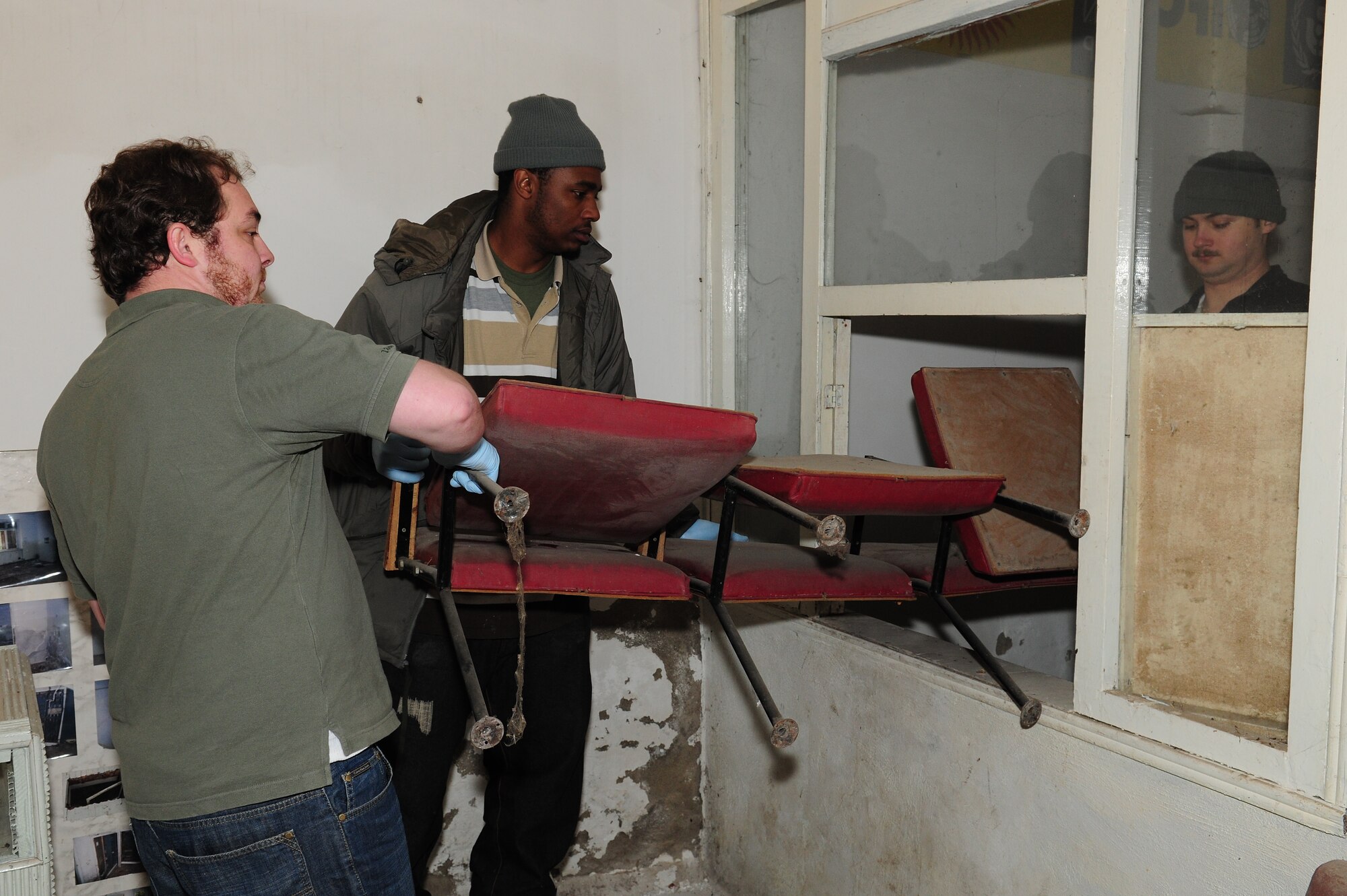 Ragan Hatcher, “JJ” Moore, and 1st Lt. Nick Herr move furniture from one room to another via a window in a building that will soon be renovated to become the Crisis Center for Women in Bishkek, Kyrgyzstan, March 5. Transit Center at Manas Airmen, together with the Kyrgyz Congress of Women, will help make the crisis center a place women can come for refuge. There will be a ceremony soon to officially begin the renovations. (U.S. Air Force photo/Staff Sgt. Carolyn Viss/released)