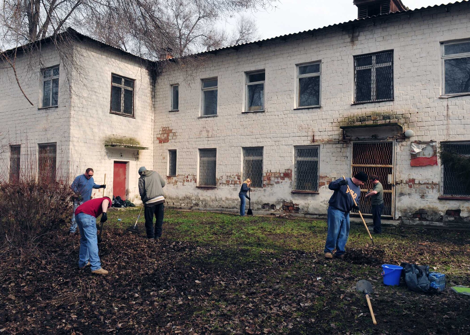 Airmen from the Transit Center at Manas, Kyrgyzstan, clean up the back of a building that will soon be renovated to become the Crisis Center for Women in Bishkek, Kyrgyzstan, March 5. Transit Center at Manas Airmen, together with the Kyrgyz Congress of Women, will help make the crisis center a place women can come for refuge. There will be a ceremony soon to officially begin the renovations. (U.S. Air Force photo/Staff Sgt. Carolyn Viss/released)