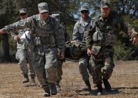 (Front to back, left to right) Airman 1st Class Chris Morie, Senior Airmen Jarod Peak, Don Brost and Tech. Sgt. John McDowell, 919th Security Forces Squadron, carry a simulated injured Airman on a litter more than 50 yards during the self-aid and buddy care scenario at Duke Field March 6.  The scenario was part of a Field Training Exercise for the 919th SFS during the UTA weekend.  Squads participated in tent building, force-on-force movements, land navigation and prisoner search.  (U.S. Air Force photo/Tech. Sgt. Samuel King Jr.) 