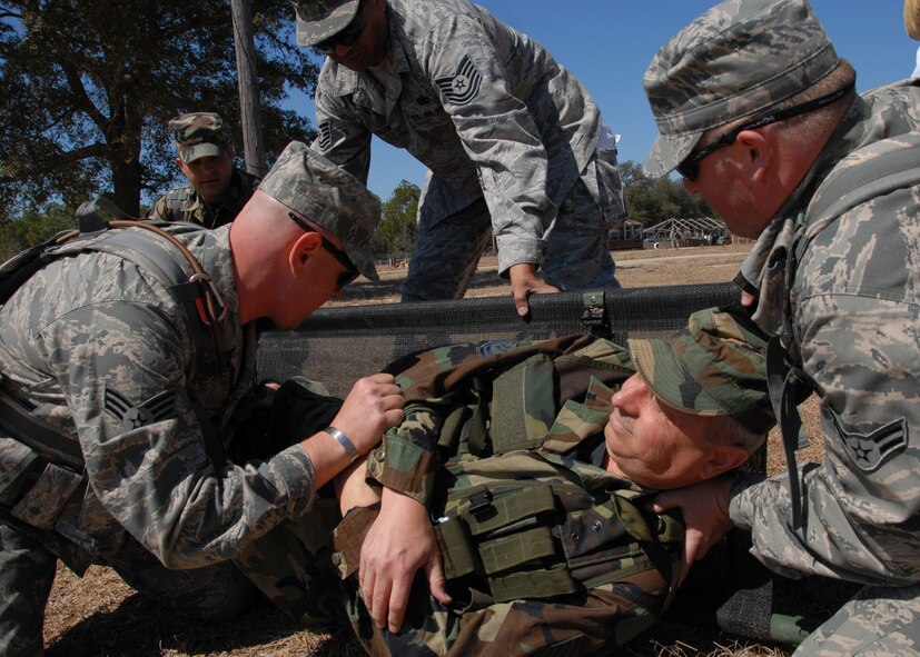 (Left to right) Senior Airman Don Brost and Airman 1st Class Chris Morie, 919th Security Forces Squadron, help Tech. Sgt. Hubert Homan onto a litter after setting his leg during the self-aid and buddy care scenario at Duke Field March 6.  The scenario was part of a Field Training Exercise for the 919th SFS during the UTA weekend.  Squads also participated in tent building, force-on-force movements, land navigation and prisoner search.  (U.S. Air Force photo/Tech. Sgt. Samuel King Jr.)