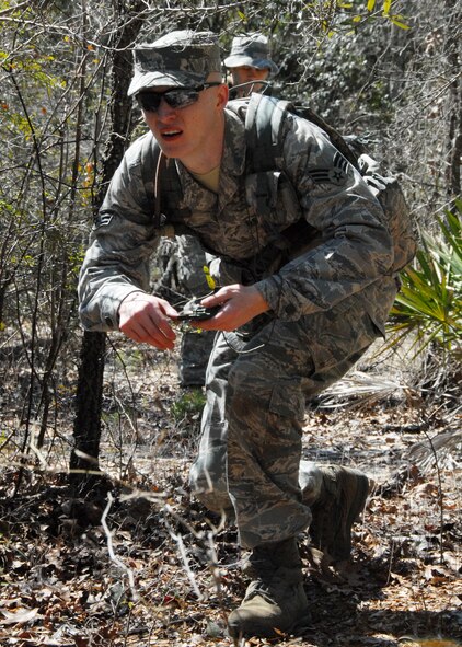 Senior Airman Zachary Mabes, 919th Security Forces Squadron, navigates his team through the dense forest of the Eglin Air Force Base range during the land navigation scenario at Duke Field March 6.  The scenario was part of a Field Training Exercise for the 919th SFS during the UTA weekend.  Squads also participated in tent building, force-on-force movements, self-aid and buddy care and prisoner search.  (U.S. Air Force photo/Tech. Sgt. Samuel King Jr.)