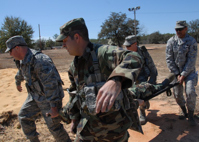 (Left to right) Airman 1st Class Chris Morie, Senior Airmen Jarod Peak, Don Brost and Tech. Sgt. John McDowell, 919th Security Forces Squadron, carry a simulated injured Airman on a litter more than 50 yards during the self-aid and buddy care scenario at Duke Field March 6.  The scenario was part of a Field Training Exercise for the 919th SFS during the UTA weekend.  Squads participated in tent building, force-on-force movements, land navigation and prisoner search.  (U.S. Air Force photo/Tech. Sgt. Samuel King Jr.) 