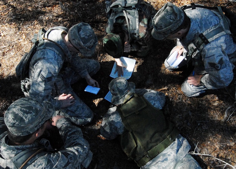 A squad of five 919th Security Forces Squadron Airmen plots a path to their objective through the dense forest of the Eglin Air Force Base range during the land navigation scenario at Duke Field March 6.  The scenario was part of a Field Training Exercise for the 919th SFS during the UTA weekend.  Squads also participated in tent building, force-on-force movements, self-aid and buddy care and prisoner search.  (U.S. Air Force photo/Tech. Sgt. Samuel King Jr.) 