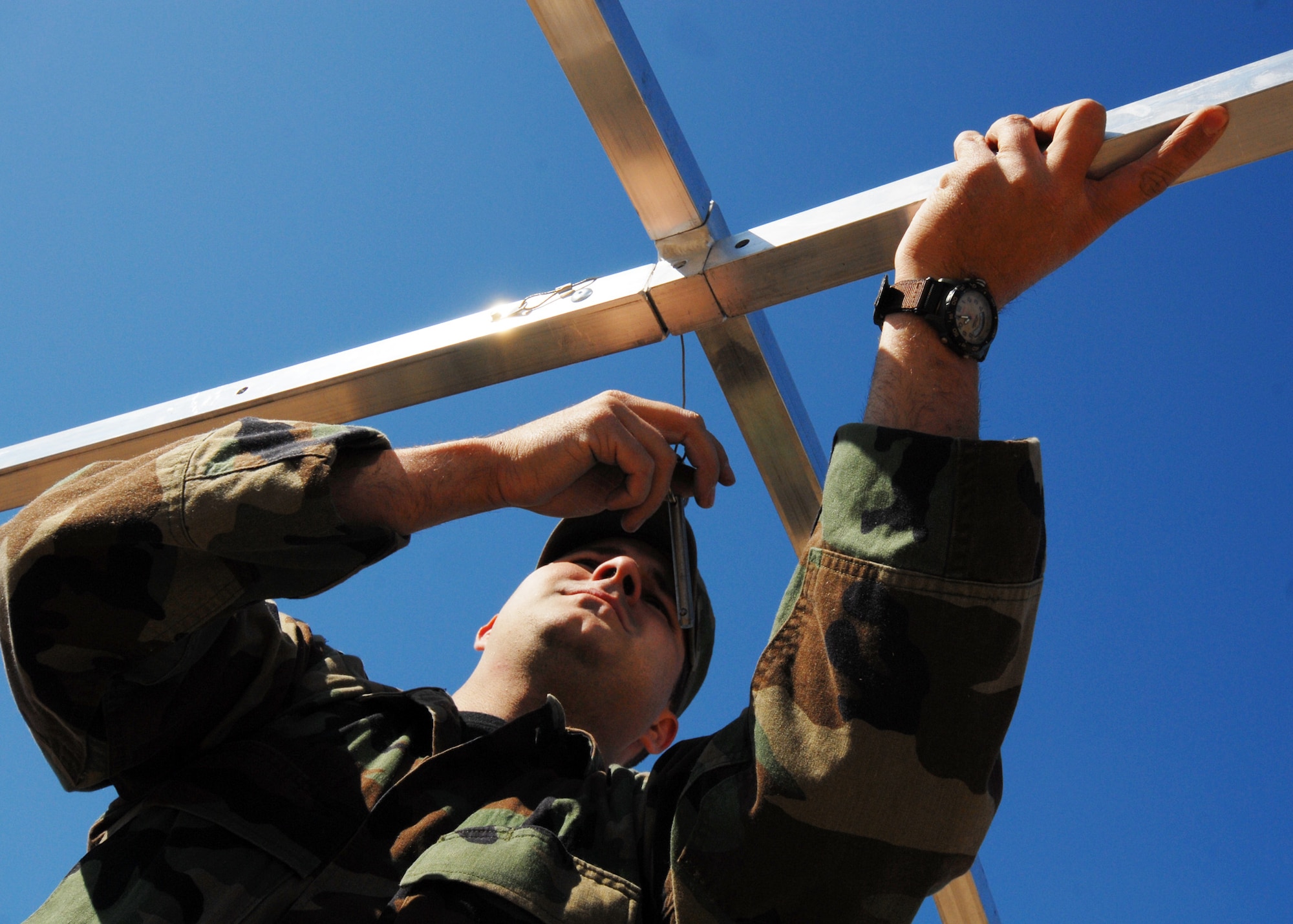 Senior Airman Jarod Peak, 919th Security Forces Squadron, holds the support beam in place before inserting the pin on a tent structure  at Duke Field March 6.  The scenario was part of a Field Training Exercise for the 919th SFS during the UTA weekend.  Squads also participated in land navigation, force-on-force movements, self-aid and buddy care and prisoner search.  (U.S. Air Force photo/Tech. Sgt. Samuel King Jr.)