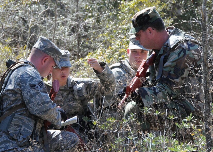 Tech. Sgt. Candice Wahowski, 919th Security Forces Squadron, directs her squad North during the land navigation scenario at Duke Field March 6.  The scenario was part of a Field Training Exercise for the 919th SFS during the UTA weekend.  Squads also participated in tent building, force-on-force movements, self-aid and buddy care and prisoner search.  (U.S. Air Force photo/Staff Sgt. Jon McCallum)
