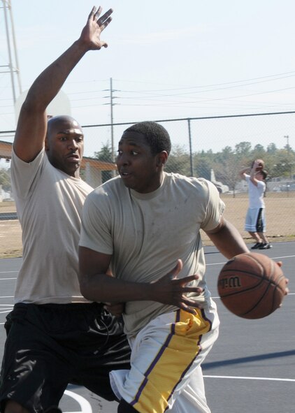David Cason drives to the basket against Damien Fantroy in the first game of the three-on-three basketball tournament March 7 at Duke Field.  Cason’s team won two straight games in the single-elimination tournament to win.  (U.S. Air Force photo/Tech. Sgt. Samuel King Jr.)