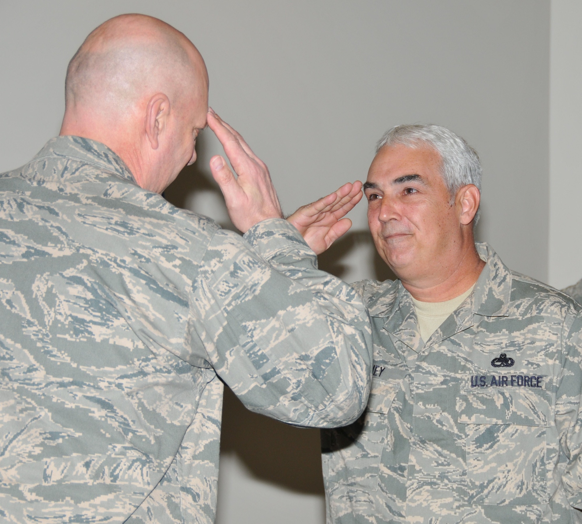 Chief Master Sgt. Charles Gaffney (center) salutes Col. Kerry Kohler, commander of the 403rd Maintenance Group, as Maj. Gen. James Rubeor, 22nd Air Force commander,  looks on. Chief Gaffney received an award named in his honor on March 6, 2010. (U.S. Air Force photo by Senior Airman Kimberly Erickson)