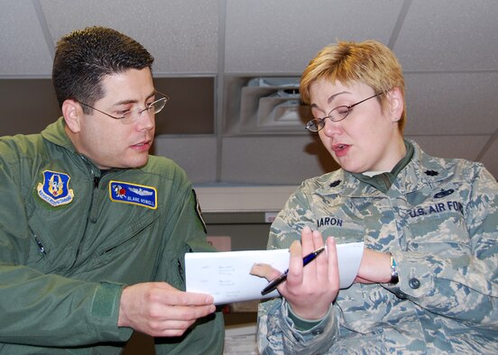 Lieutenant Col. Stephanie Aaron (right), 514th Air Mobility Operations Flight director of operations, review details for project, with co-worker Maj. Blaine Howell at the flight's office on Joint Base McGuire-Dix-Lakehurst Feb. 16, 2010. The 514th AMOF will soon expand from a flight into a squadron. (U.S. Air Force photo/Staff Sgt. Shawn J. Jones)