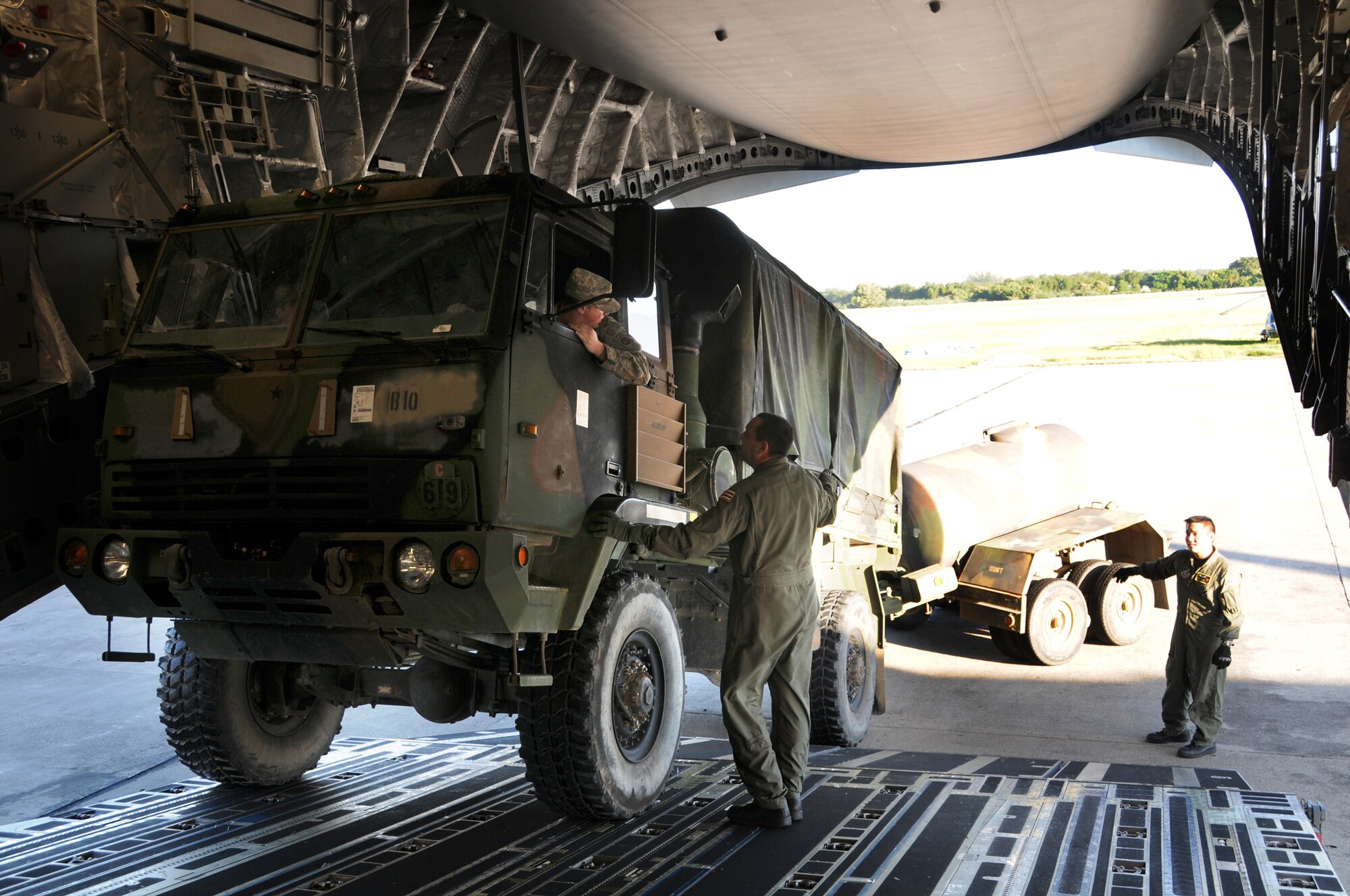Members of the Hawaii Air National Guard help unload
supplies in support of Operation United Command, January 21, 2010. (Air Force Times photo/Sheila Vemmer)