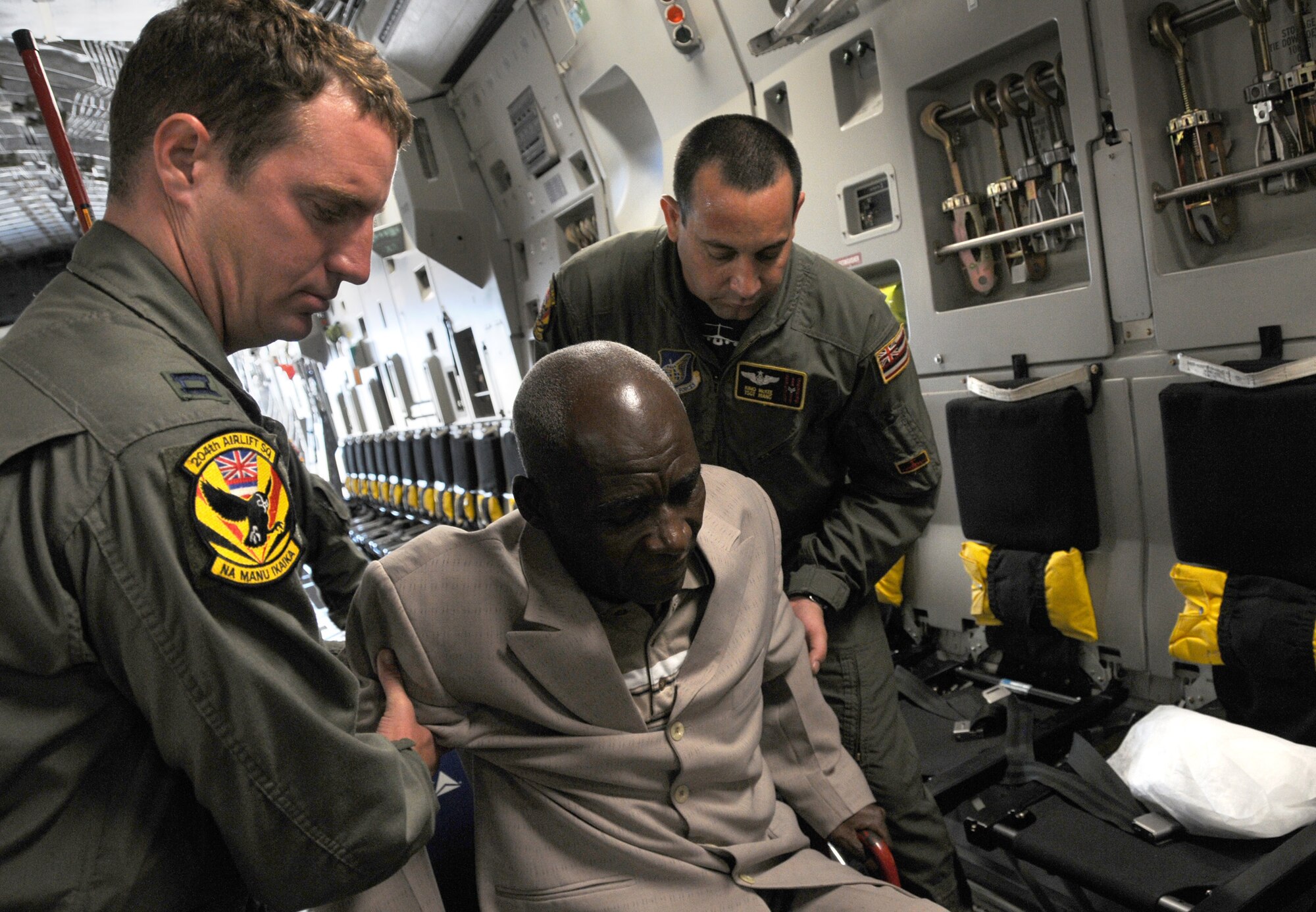 Members of the Hawaii Air National Guard assist a Haitian
citizen as he boards the C-17 in Port-au-Prince Haiti, Thursday, January 21, 2010. (Air Force Times photo/Sheila Vemmer)
