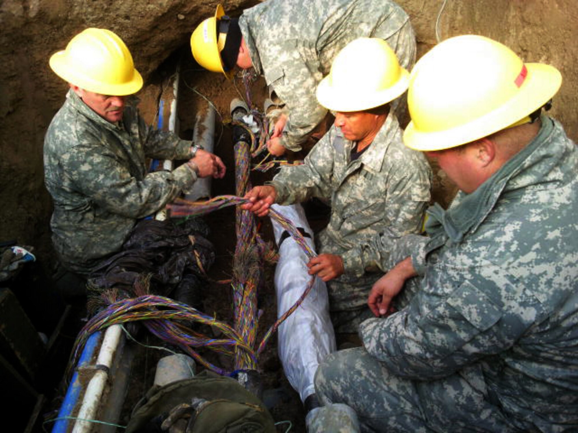 Members of the 130th Engineering Installation Squadron repair three major cables containing over 8,000 phone lines at Mountain Home Air Force Base, Idaho. They recently responded to an Air Force-wide call for emergency assistance to repair the cables  after a contractor dug into the base's telephone lines causing them to lose over half of their connections. U.S. Air Force courtesy photo (released).              