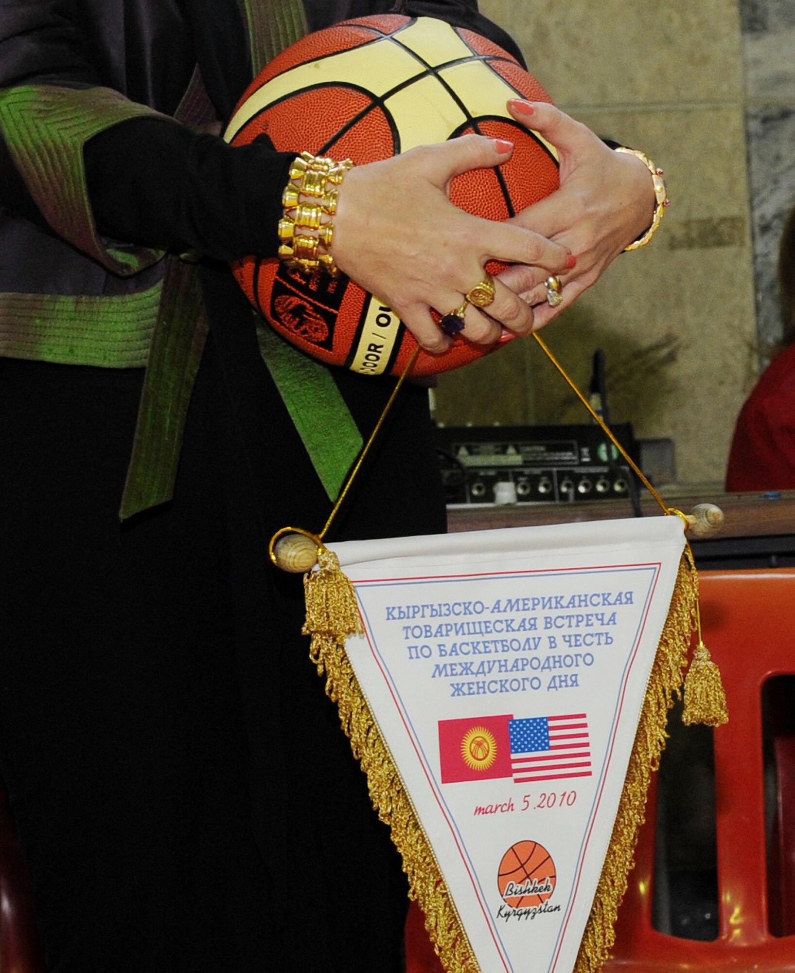 U.S. Ambassador to Kyrgyzstan, Tatiana Gfoeller, holds a commemorative basketball and banner before presenting it to the winning team during the closing ceremony of the friendly basketball game against the Technical University at the Palace of Sport in Bishkek, Kyrgyzstan, March 5, 2010. The team participated in friendly match organized to unite the women in honor of International Women's Day. (U.S. Air Force photo/Senior Airman Nichelle Anderson/released)
