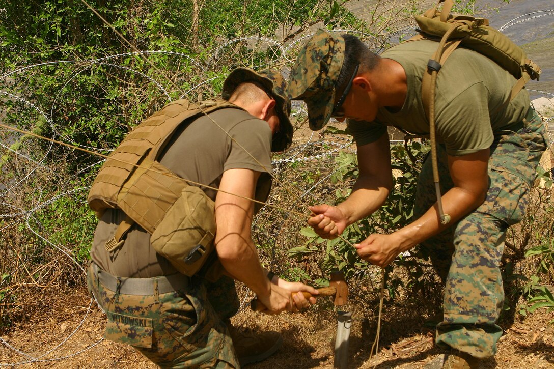 Cpl. Jesse John Witkowski (left), a construction wireman, hammers a stake into the ground, while Cpl. Sean Varela, a radio operator, pulls pole strings tight during the 31st Marine Expeditionary Unit’s (MEU), construction phase of camp facilities in support of Balikatan 2010 (BK ’10).  Servicemembers from the Armed Forces of the Philippines (AFP) and the 31st MEU are training together during BK ’10 to hone their civil-military interoperability skills to ensure more responsive, efficient and effective relief efforts. (Official Marine Corps photo by Cpl. Michael A. Bianco)