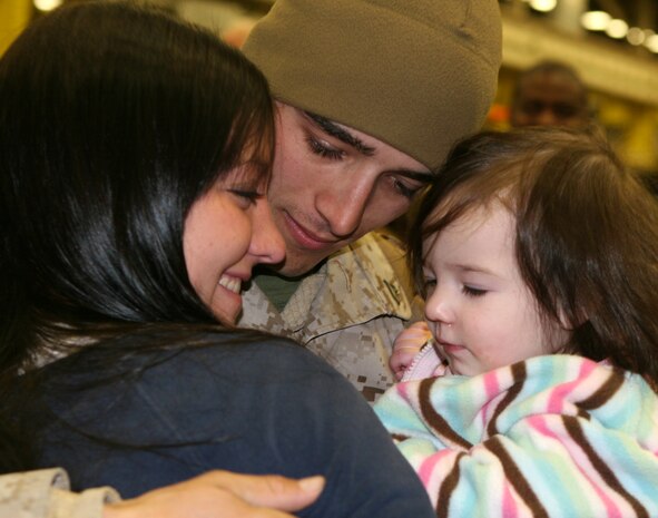 Cpl. Curtis Wiseman, a warehouse clerk with Combat Logistics Company 252, Combat Logistics Regiment 25, 2nd Marine Logistics Group, hugs his wife and daughter upon his arrival to Camp Lejeune, N.C. after returning from Afghanistan, March 8, 2010.  Marines from CLC-252 and Combat Logistics Regiment 2, 2nd MLG, were deployed to Camp Leatherneck in Helmand Province Afghanistan. (U.S. Marine Corps photo by Lance Cpl. Melissa A. Latty)