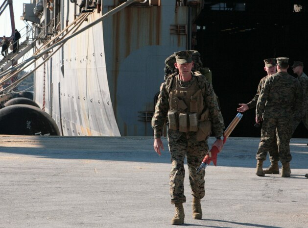Sgt. Maj. Steven L. Lunsford, battalion sergeant major, Combat Logistics Battalion 22, Combat Logistics Regiment 27, 2nd Marine Logistics Group, carries the battalion guidon off of the USS Carter Hall at the North Carolina State Port in Morehead City, N.C., March 9, 2010.   Approximately 250 Marines and sailors from CLB-22 deployed to Haiti to provide humanitarian assistance and disaster relief to help alleviate the suffering of the people of Haiti after the horrific earthquake that struck Jan. 12, 2010. The battalion had just returned from a deployment to the U.S. Central Command Theater in the Middle East with the 22nd Marine Expeditionary Unit, one month before the earthquake.  “The fact that they came back from a seven-month deployment and less than 72-hours after hearing about [the earthquake] they were equipped and loaded on a naval ship says tons of things about the quality of Marines we have,” Lunsford said.    (U.S. Marine Corps photo by Cpl. Meghan J. Canlas)