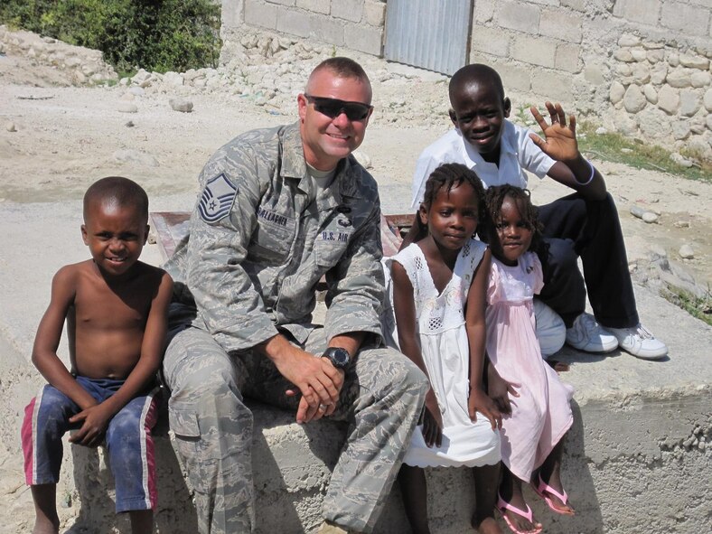 PORT-AU-PRINCE, Haiti -- Master Sgt. Donald Gallagher, 823rd Expeditionary Security Forces Squadron flight sergeant, visits with local Haitian children here Feb. 18. The 823rd ESFS deployed from Moody Air Force Base, Ga., in January to help provide security at the Toussaint L'Ouverture International Airport in Port-au-Prince, Haiti. (U.S. Air Force photo by Senior Airman Ryan Pieper)