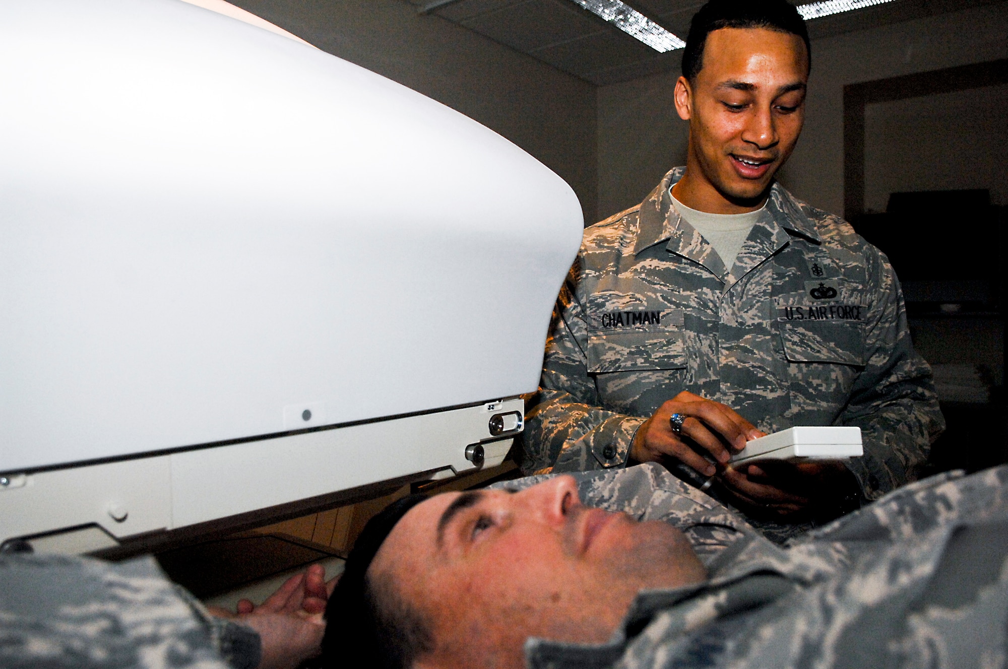 ELMENDORF AIR FORCE BASE, Alaska – Master Sgt. Joel Swiderski, 3rd Medical Group radiation safety officer (lying down) and Tech. Sgt. Daryl Chatman, 3rd Medical Group Nuclear Medicine technologist (standing) demonstrate how patients going through Nuclear Medicine would be scanned by a Gamma camera. The camera is sensitive enough to pick up faint traces of radiation injected into the patient’s bodies. (U.S. Air Force photo/ Airman 1st Class Jack Sanders)