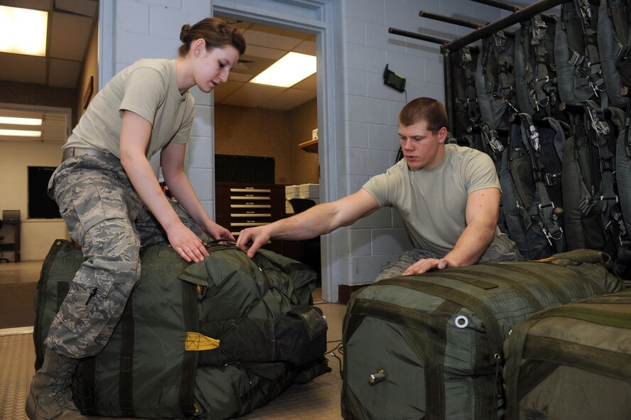 MINOT AIR FORCE BASE, N.D. – Senior Airman Cody Lytle, 5th Operations Support Squadron aircrew flight equipment technician, and Airman 1st Class Christian Krueger, 5th OSS aircrew flight equipment apprentice, compress B-52H Stratofortress drag chute survival kits at the AFE parachute shop Mar. 4. Aircrew flight equipment members inspect and maintain life-saving appliances and gear for the B-52H aircraft as well as all 5th Bomb Wing aircrew personnel. (U.S. Air Force photo by Senior Airman Jesse Lopez)