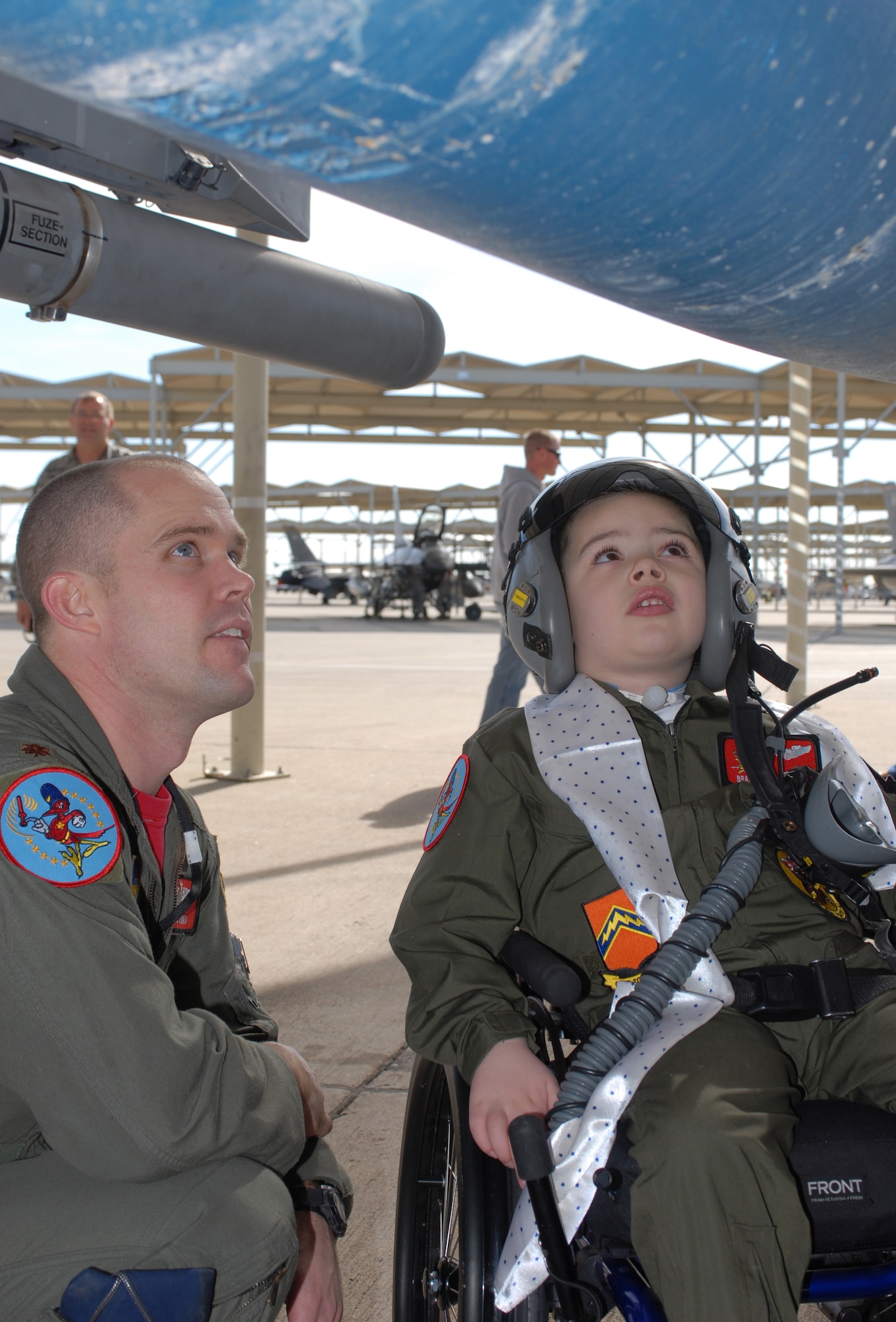 Maj. Bryan Unks, 56th Training Squadron instructor pilot, shows Brandon "Hulk" Davis the simulated bombs on the F-16 Feb. 26 during a pilot-for-a-day tour. (U.S. Air Force photo by Airman 1st Class Sandra Welch)