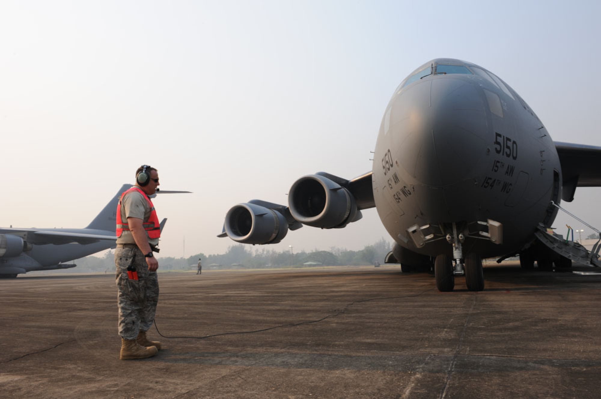 Staff Sgt. Travis Weigel, a crew chief from the 703rd Aircraft Maintenance at Elmendorf Air Force, Alaska, communicates with C-17 Globemaster III pilots before the crew departs for a mission in support of Cope Tiger 2010 at Udon Thani Royal Thai Air Force Base, Thailand, March 8.  Cope Tiger 2010 is an annual multilateral aerial large force exercise conducted in Thailand that includes humanitarian and civic assistance programs. This year's exercise takes place primarily at Udon Thani and Korat Royal Thai Air Force Bases March 1-12. (U.S.  Air Force photo/Tech Sgt. Cohen A. Young)