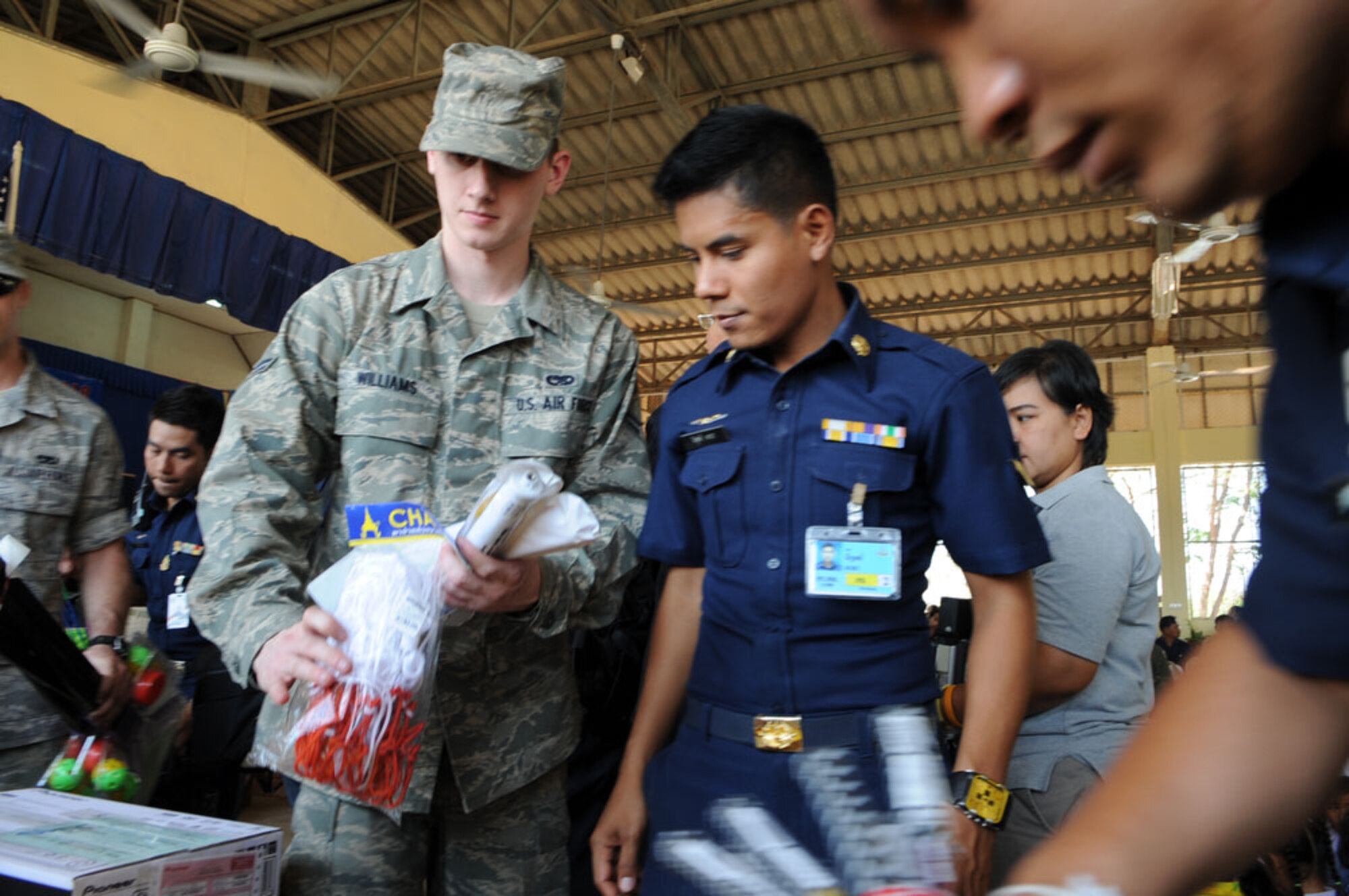 Airman 1st Class Cass Williams (left), a native of Arcadia, Fla., and a member of the 19th Aircraft Maintenance Squadron at Elmendorf Air Force Base, Alaska delivers toys for donation to children from the Ban Nong Sroung School in Ban Nong Sroung, Thailand, March 4.  U.S., Thai and Singaporean airmen joined together to provide medical, dental and optometry care to local Thai residents, in addition to donating money, school supplies, toys and games to Thai children as part of exercise Cope Tiger 2010.  Cope Tiger, conducted this year March 1 to 12 from both Korat and Udon Thani Royal Thai Air Force Bases in Thailand, is a multilateral aerial large force exercise aimed at improving interoperability and strengthening relationships with partner nations in the Asia-Pacific region. (U.S. Air Force photo/Tech Sgt. Cohen A. Young)