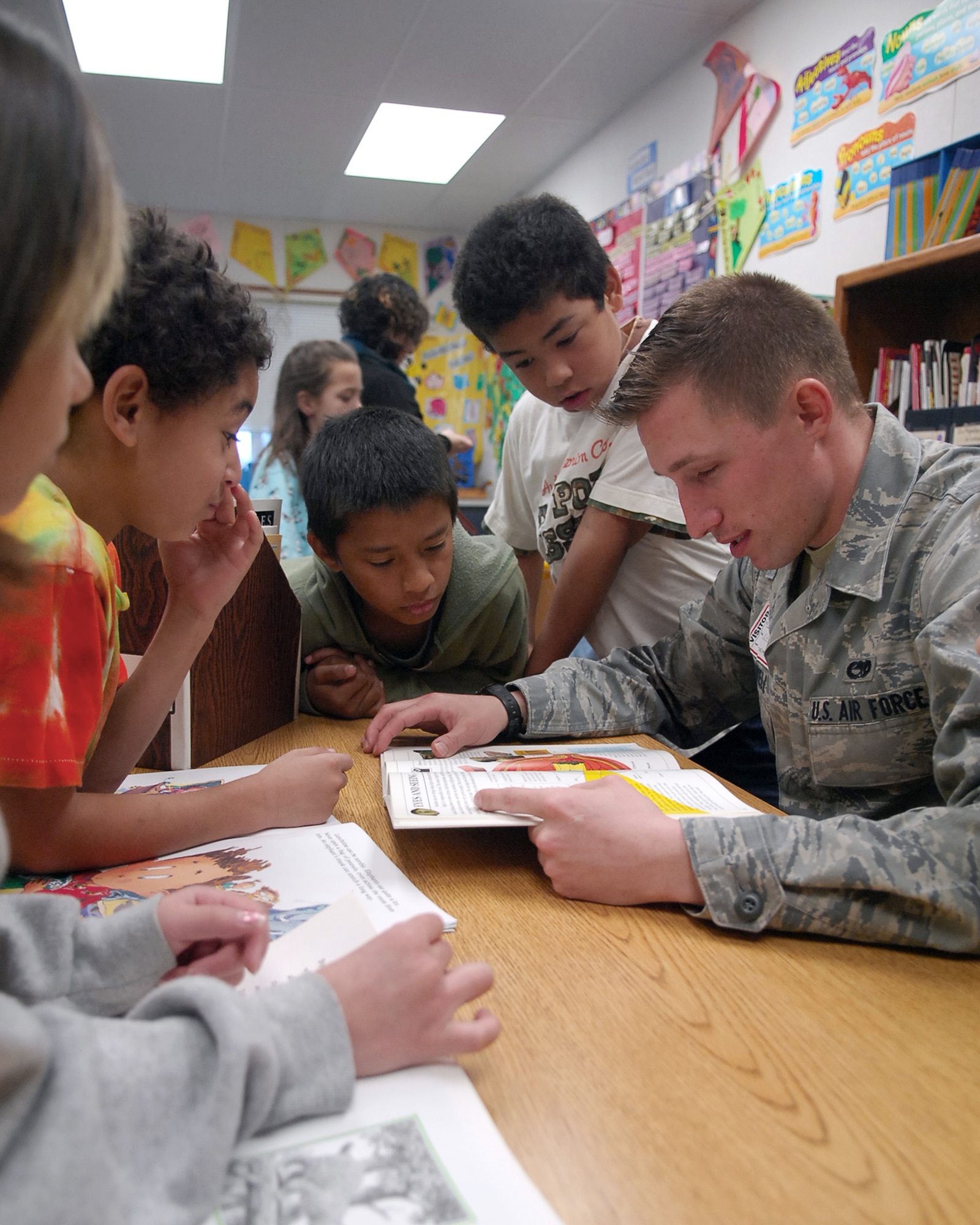 Airman 1st Class Christopher McDowell a book as children listen attentively at Arboga Elementary School, March 2. Airman McDowell is from the 9th Communication Squadron. (U.S. Air Force photo/Senior Airman Kevin Iinuma)