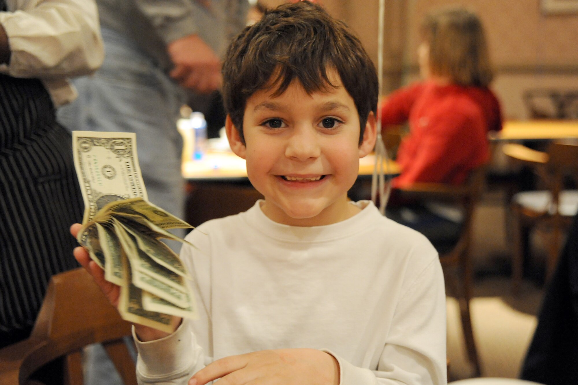 Chase Witmore shows off the cash winnings he received for his bingo during Family Night at the Charleston Club March 4, 2010, at Joint Base Charleston, S.C. Families enjoyed pizza, spaghetti, ice cream and bingo at this month's event. The next scheduled Family Night is set for April 1, 2010. Chase is the son of Jake and Heather Witmore who were guests of a JB CHS member for the night. (U.S. Air Force photo/Staff Sgt. Marie Brown)