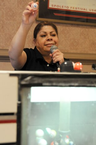 Dora Perez holds up the next bingo number to be called during Family Night at the Charleston Club March 4, 2010, at Joint Base Charleston, S.C. The Charleston Club hosts Family Night the first Thursday of every month. The next scheduled Family Night is set for April 1, 2010. Ms. Perez is a staff member with the Charleston Club. (U.S. Air Force photo/Staff Sgt. Marie Brown)